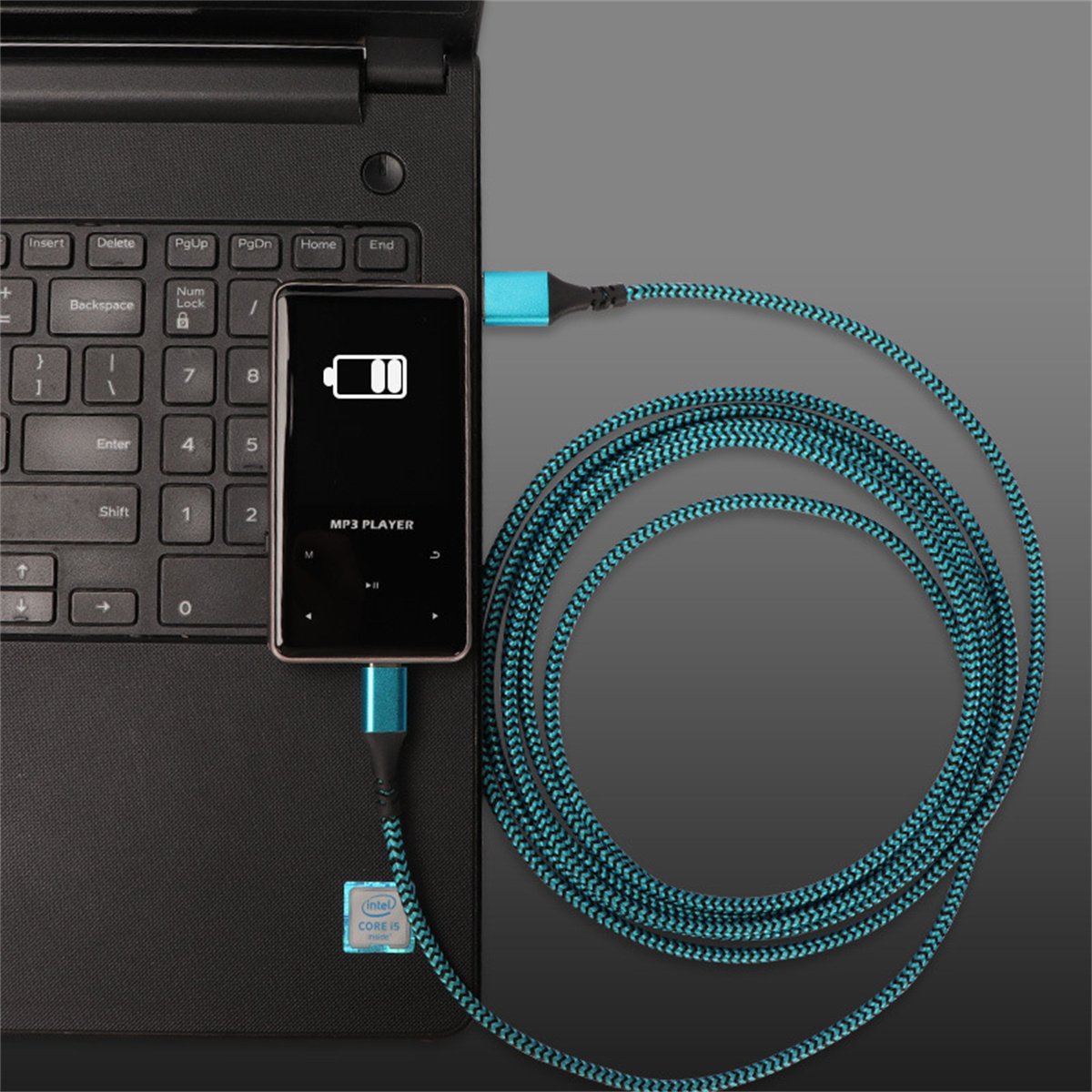 Ein MP3-Player, der an einem Laptop aufgeladen wird. Ein blaues und schwarzes Kabel verbindet den Player mit dem Laptop. Der Player zeigt ein Akkusymbol an.
