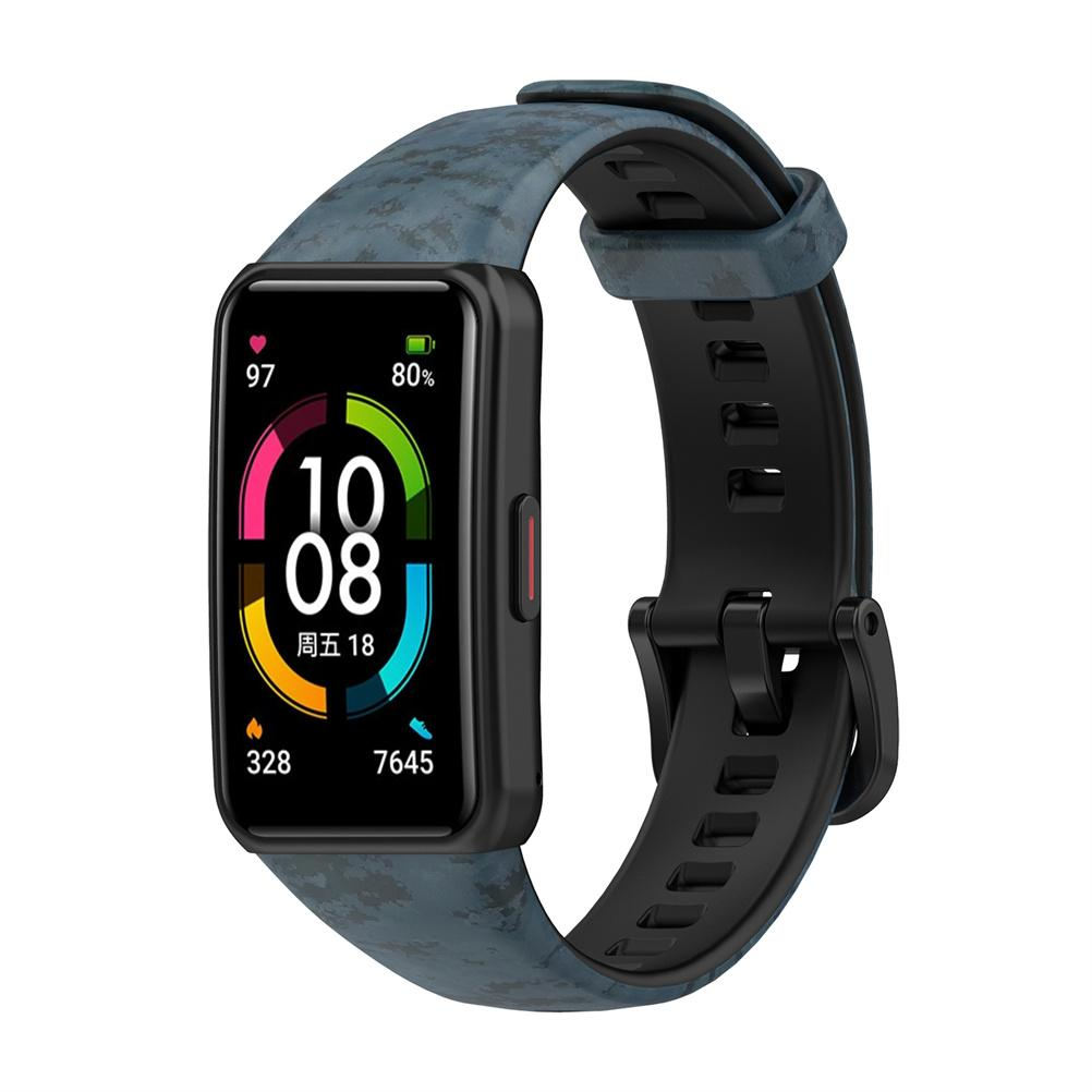 Eine schwarze Smartwatch mit blauem Armband. Das Zifferblatt zeigt Datum, Uhrzeit, Akku und Schritte. Der Hintergrund ist weiß.