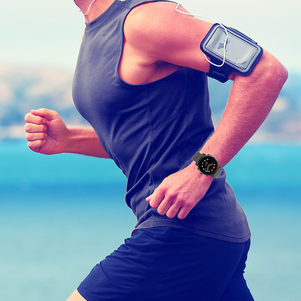 Ein Mann läuft, trägt eine Smartwatch, eine Armband-Telefonhalterung und ein Tanktop. Der Hintergrund zeigt Meer und Himmel.