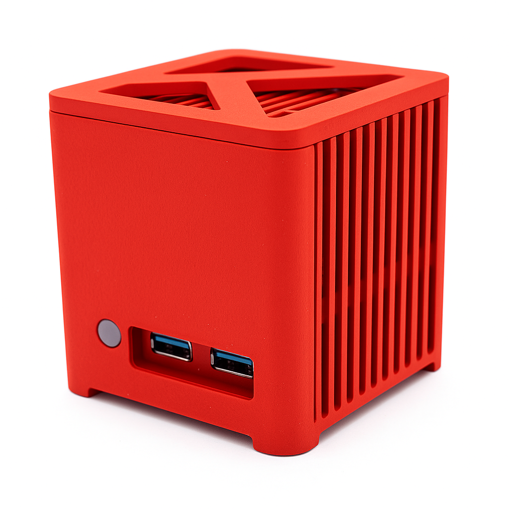Czerwona obudowa komputera w kształcie kostki. Posiada przycisk zasilania, dwa porty USB i wentylowany wierzch.