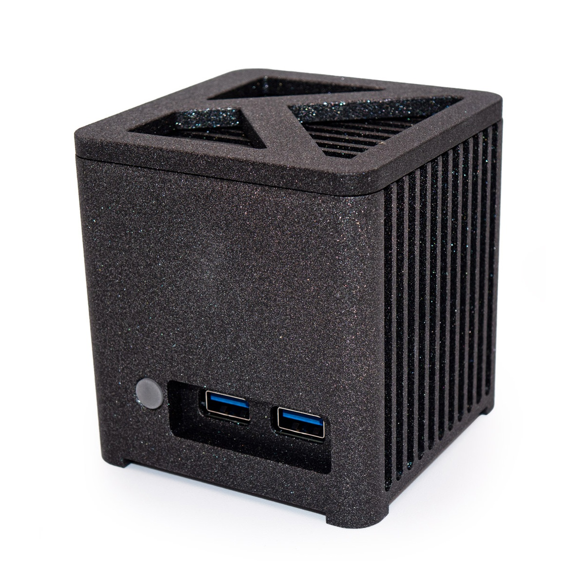 Czarne urządzenie w kształcie kostki z portami USB i wentylacją. Ma teksturowaną powierzchnię, przycisk i białe tło.