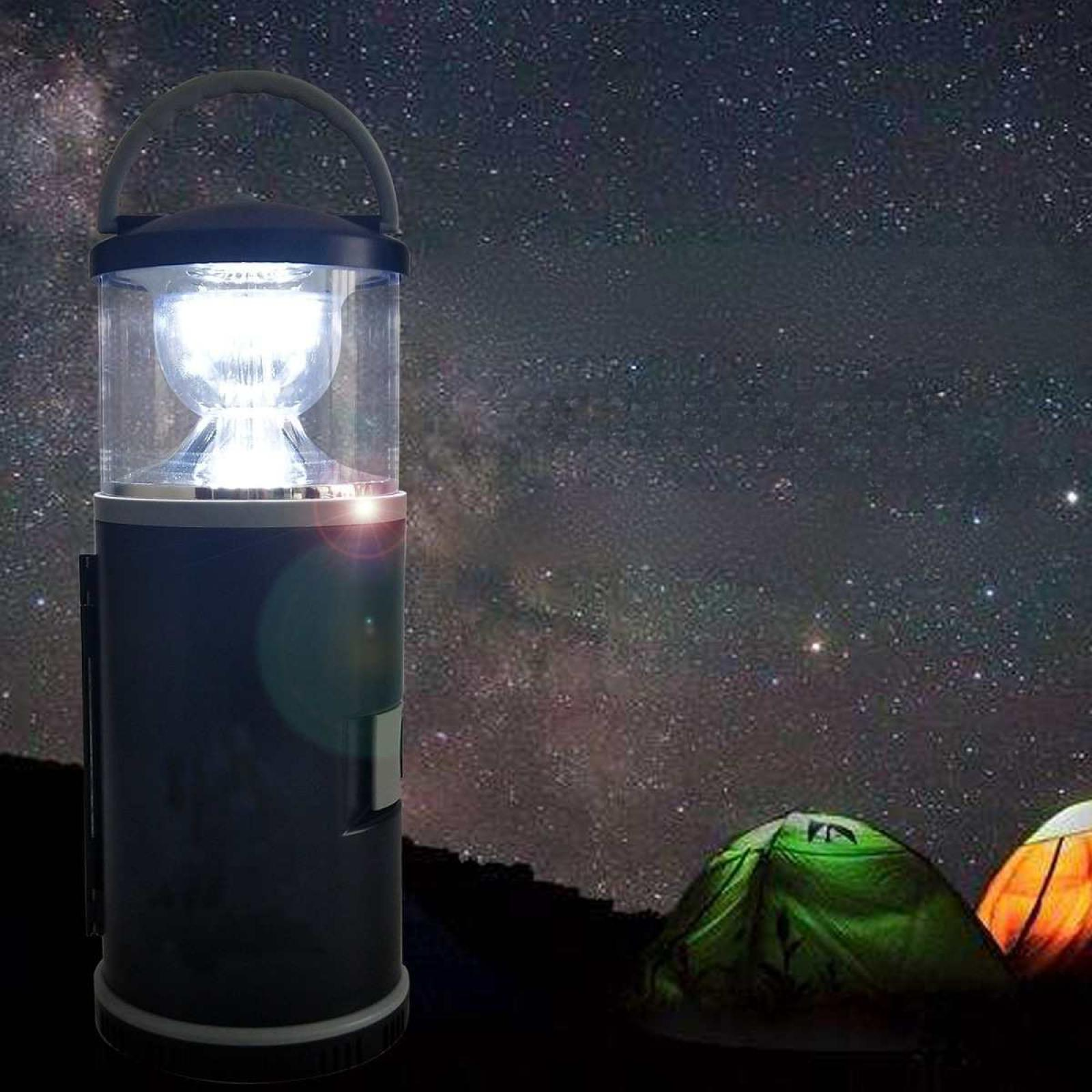 Eine leuchtende Campinglaterne steht vor einem Sternenhimmel. Im Hintergrund sind zwei Zelte zu sehen.