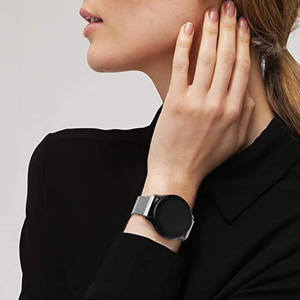 Frau mit schwarzer Smartwatch und silbernem Mesh-Armband. Sie trägt ein schwarzes Hemd und berührt ihren Hals mit der Hand.