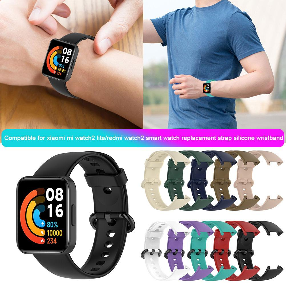 Eine Person trägt eine schwarze Smartwatch. Die Uhr zeigt Datum und Uhrzeit an. Mehrere farbige Armbänder werden angezeigt.