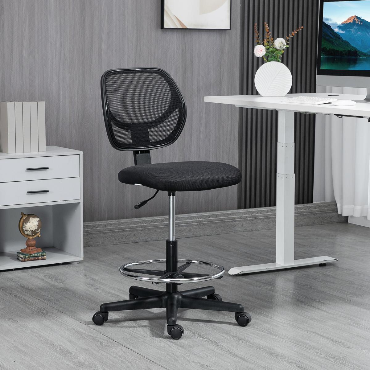 Schwarzer Bürostuhl mit Netzrücken und Fußstütze. Weißer Schreibtisch mit Computer, Blumen und Dekoration. Graue Wände und Boden.