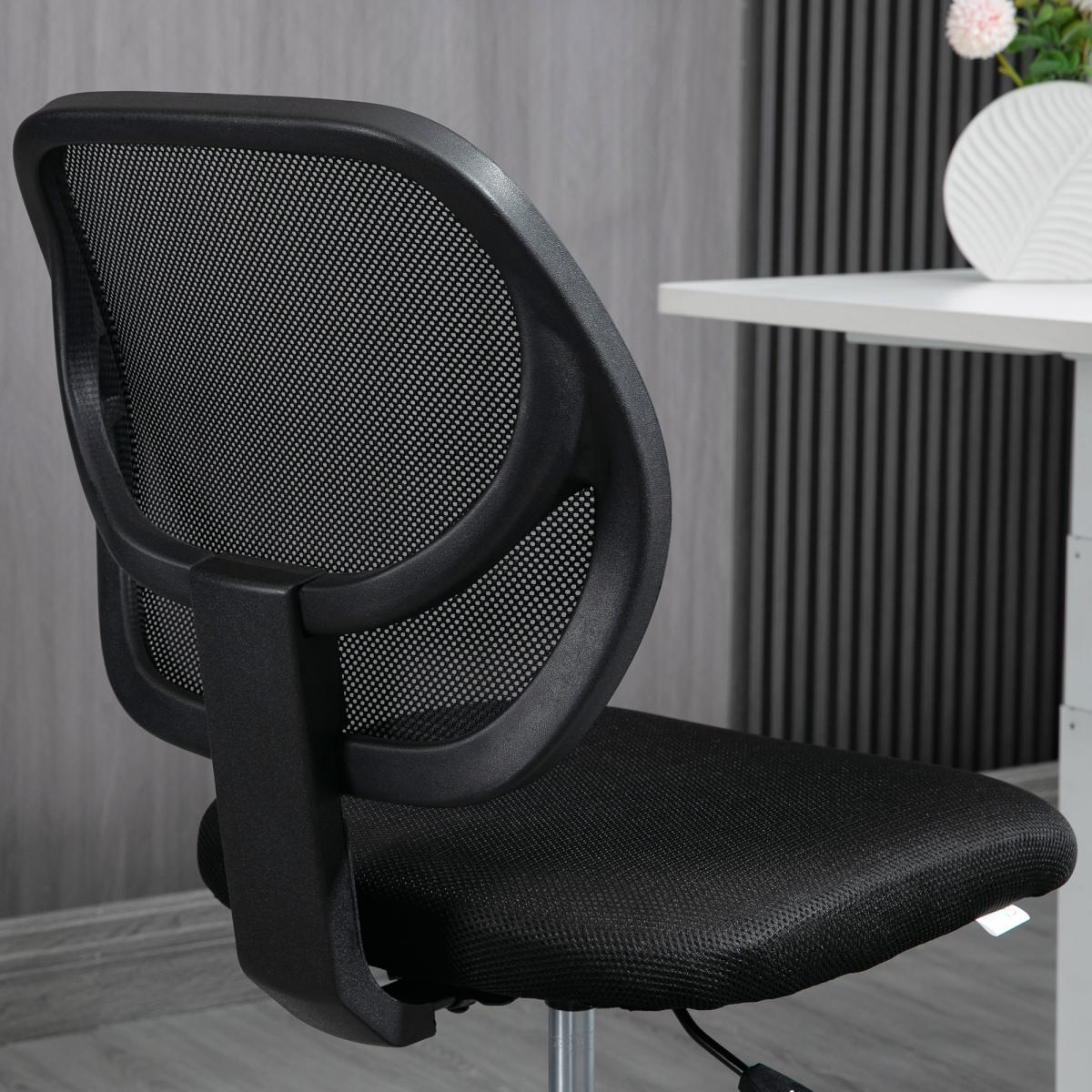 Schwarzer Bürostuhl mit Netzrücken. Weißer Tisch und dekorative Vase im Hintergrund. Holzwand.
