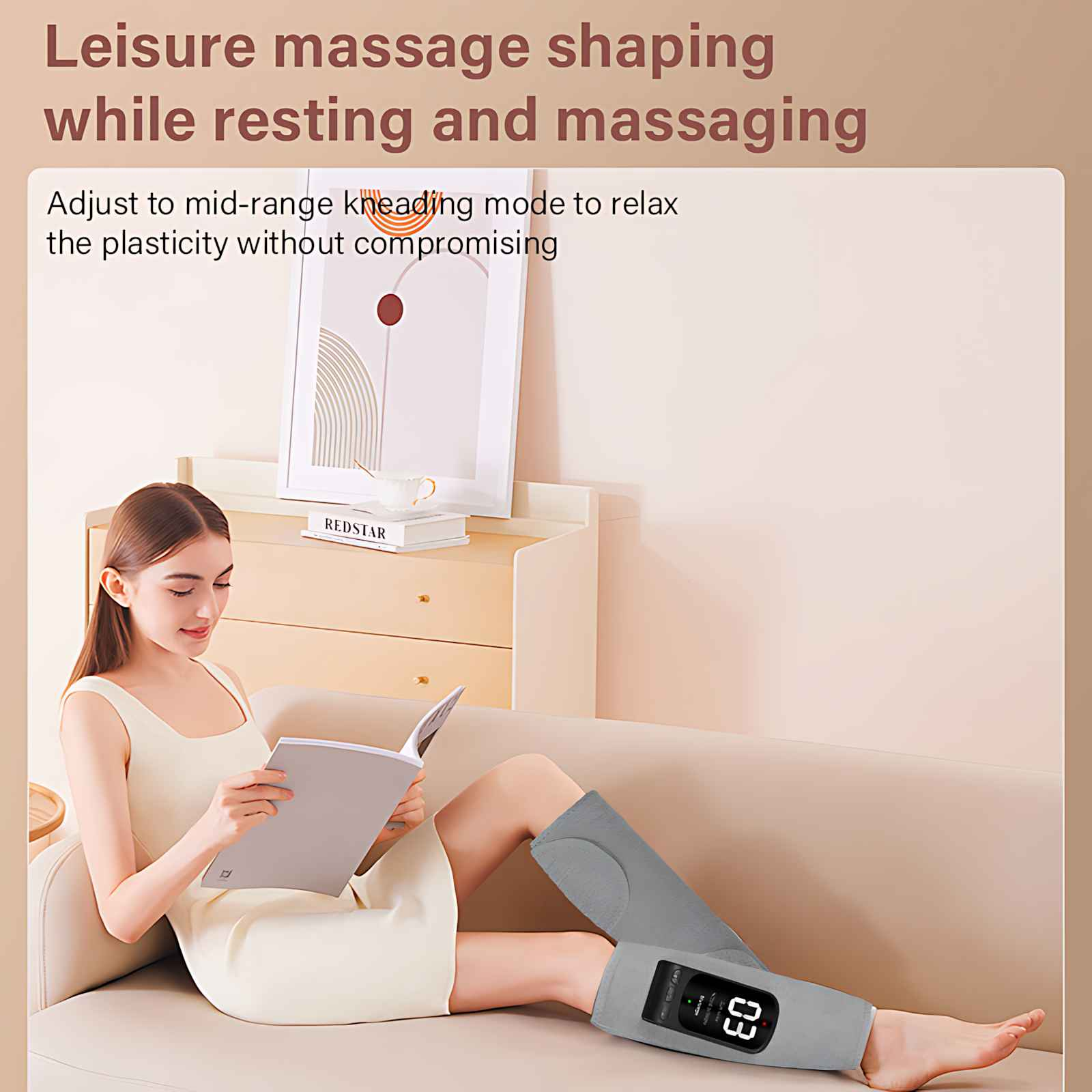 Frau auf einem Sofa mit Beinmassagegerät, liest ein Buch. Ein Gemälde und ein Buch liegen auf einem Schrank hinter ihr.