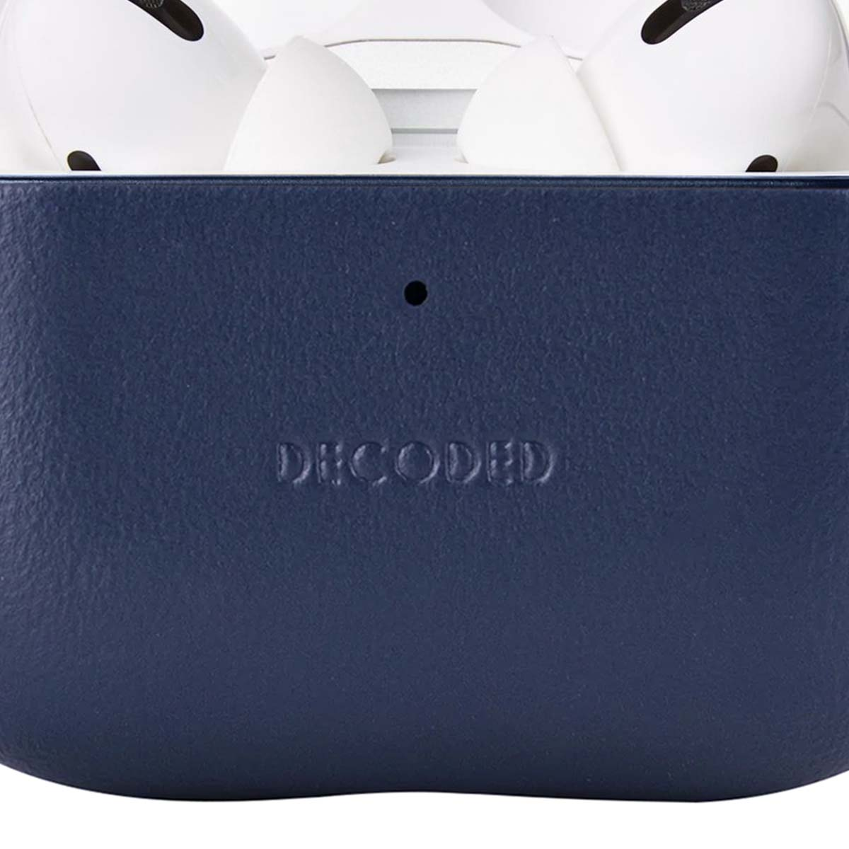 Primer plano de una funda azul oscuro con 'DECODED' grabado, con auriculares blancos encima.