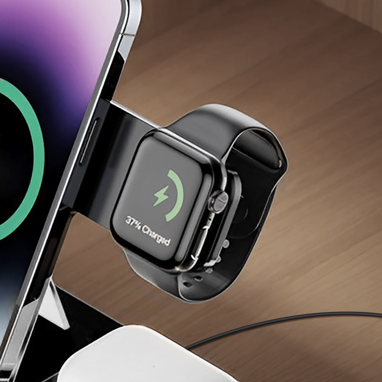 Eine Ladestation für Telefon und Smartwatch. Die Uhr lädt und zeigt 37% geladen an. Holz-Hintergrund.