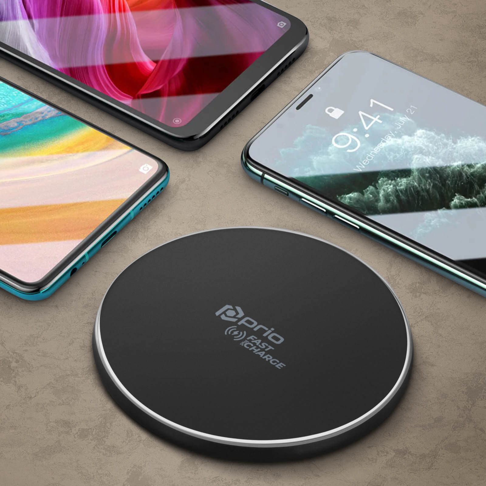 Caricabatterie wireless con telefoni. I telefoni hanno display diversi. Il caricatore è nero, i telefoni sono neri, ciano e bianchi.