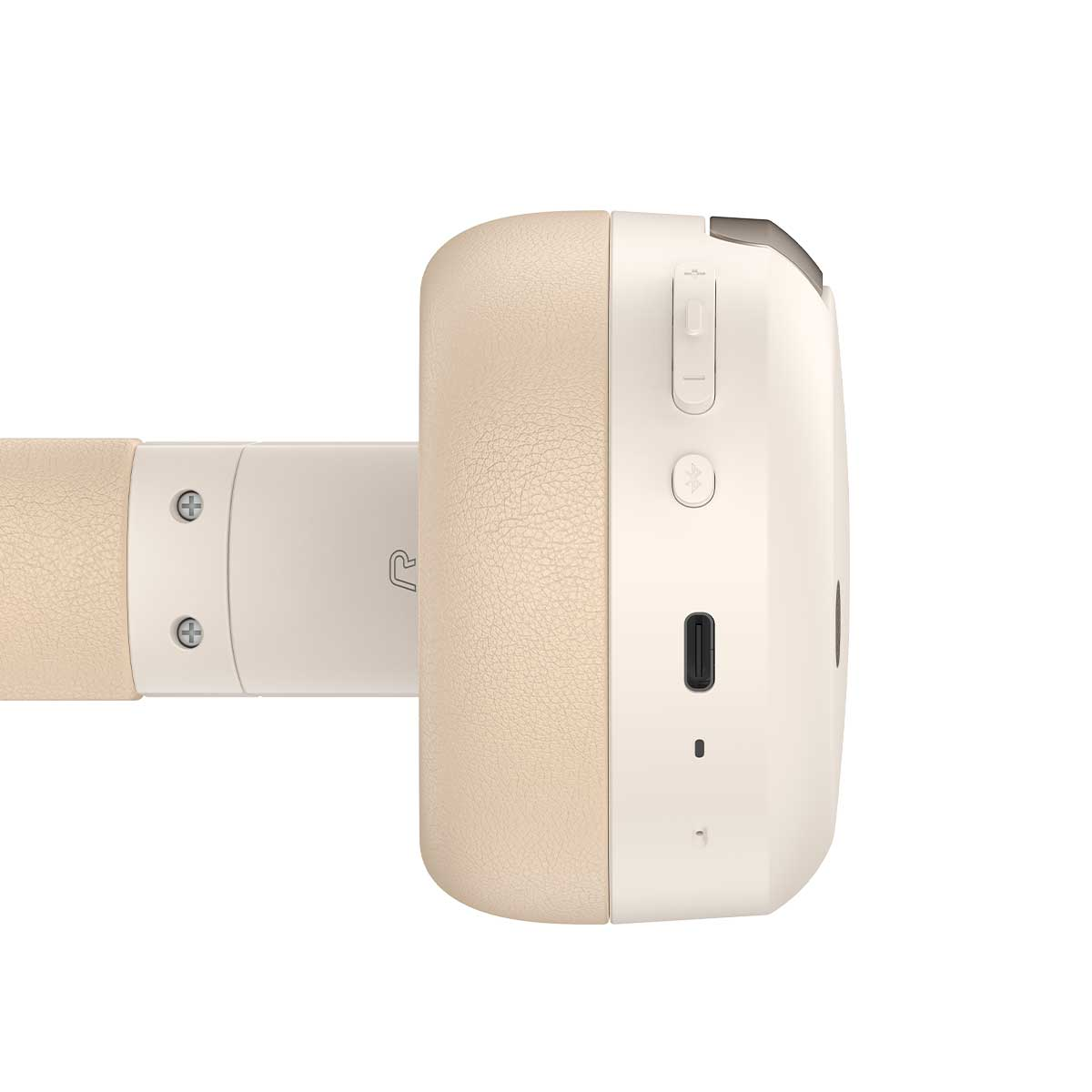 Beżowe i białe słuchawki, widok z boku. Na nauszniku widoczne są przyciski i port ładowania. Ramię jest połączone z nausznikiem.