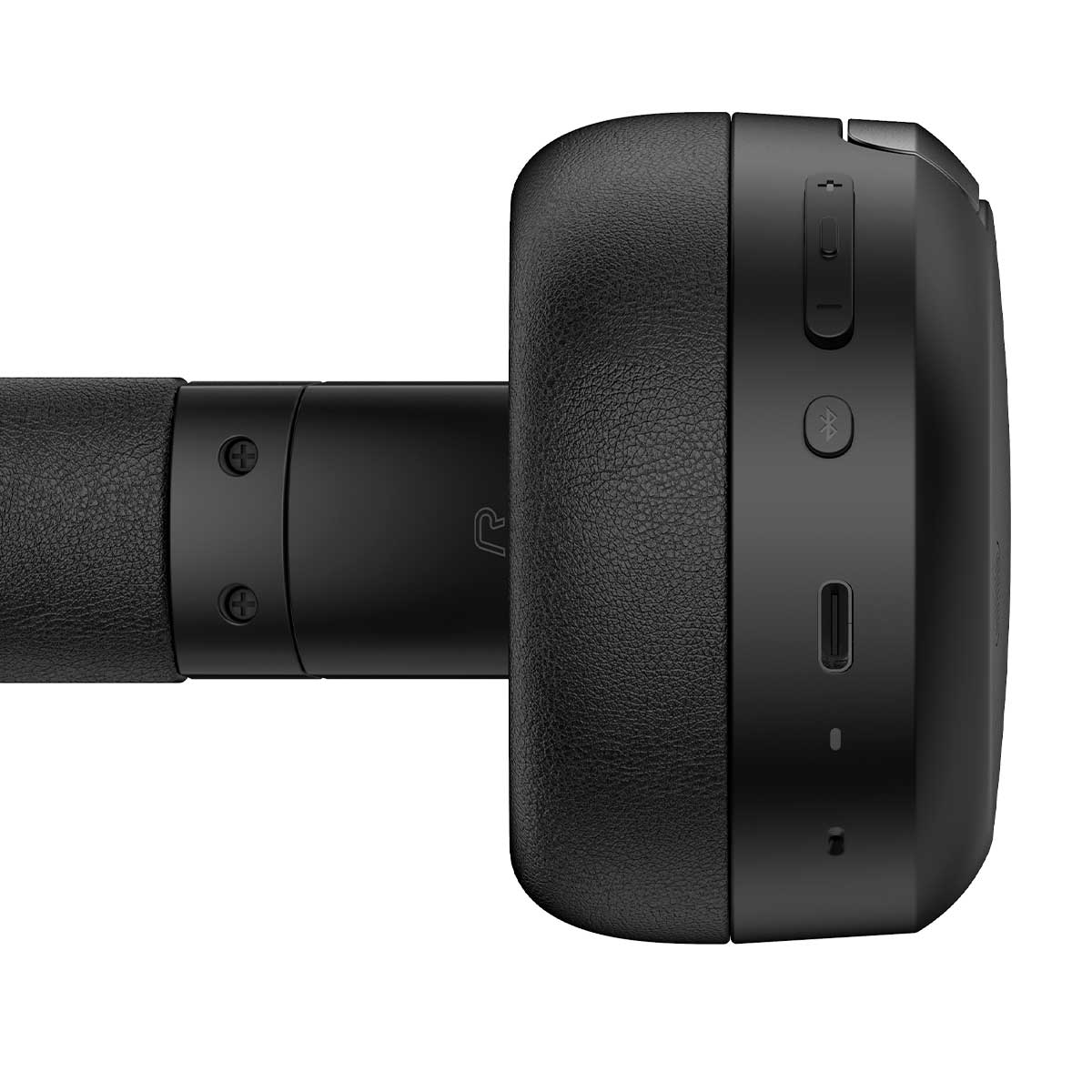 Zbliżenie czarnych słuchawek. Prawy nausznik ma przyciski i port ładowania. Pałąk jest skóropodobny.