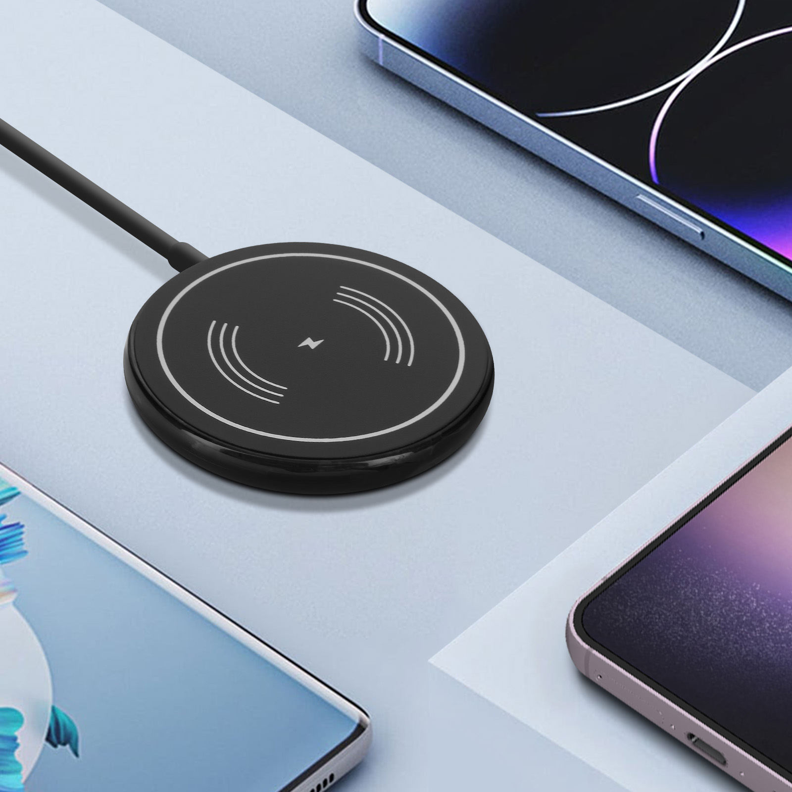 Cargador inalámbrico negro con siluetas de teléfonos. El cargador está rodeado de teléfonos inteligentes de diferentes colores.