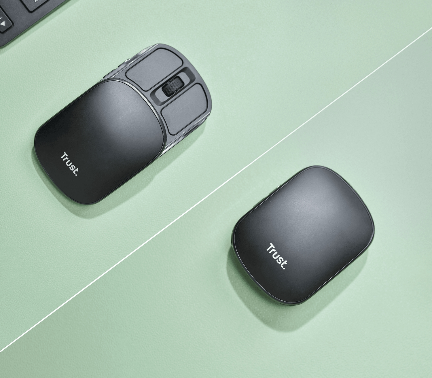 Dwie czarne myszy komputerowe na zielonej powierzchni. Jedna jest otwarta, druga zamknięta. Obie mają napis 'Trust'.