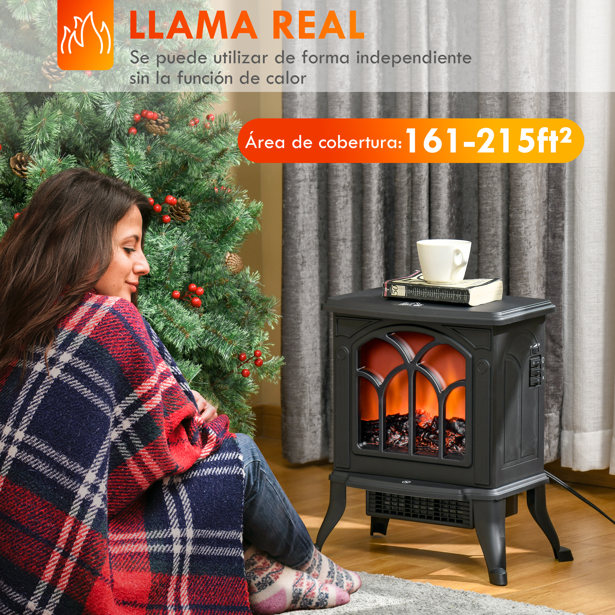 Una mujer se sienta junto a un árbol de Navidad, cerca de una chimenea negra, cubierta con una manta roja, azul y blanca.