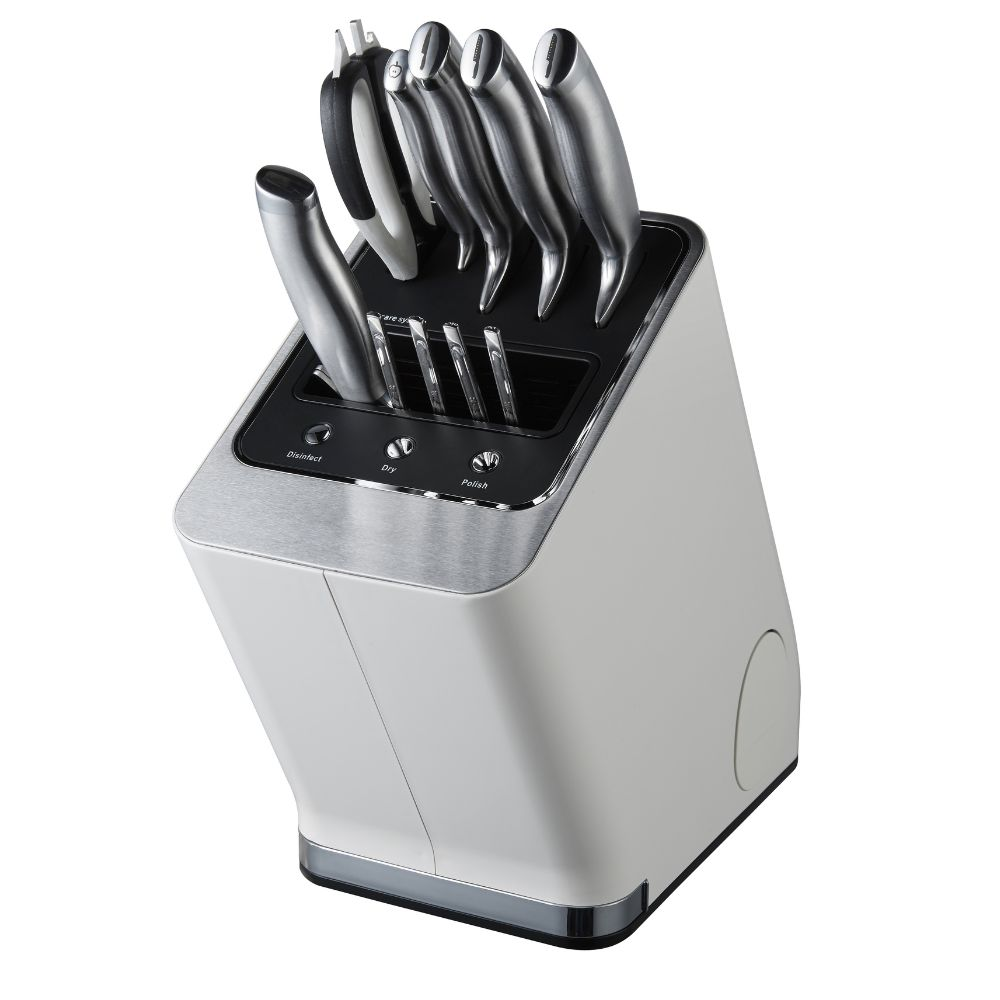 Un bloque de cuchillos blanco con cuchillos de acero inoxidable. El bloque tiene botones para desinfectar, secar y pulir. Cuchillos en el bloque.