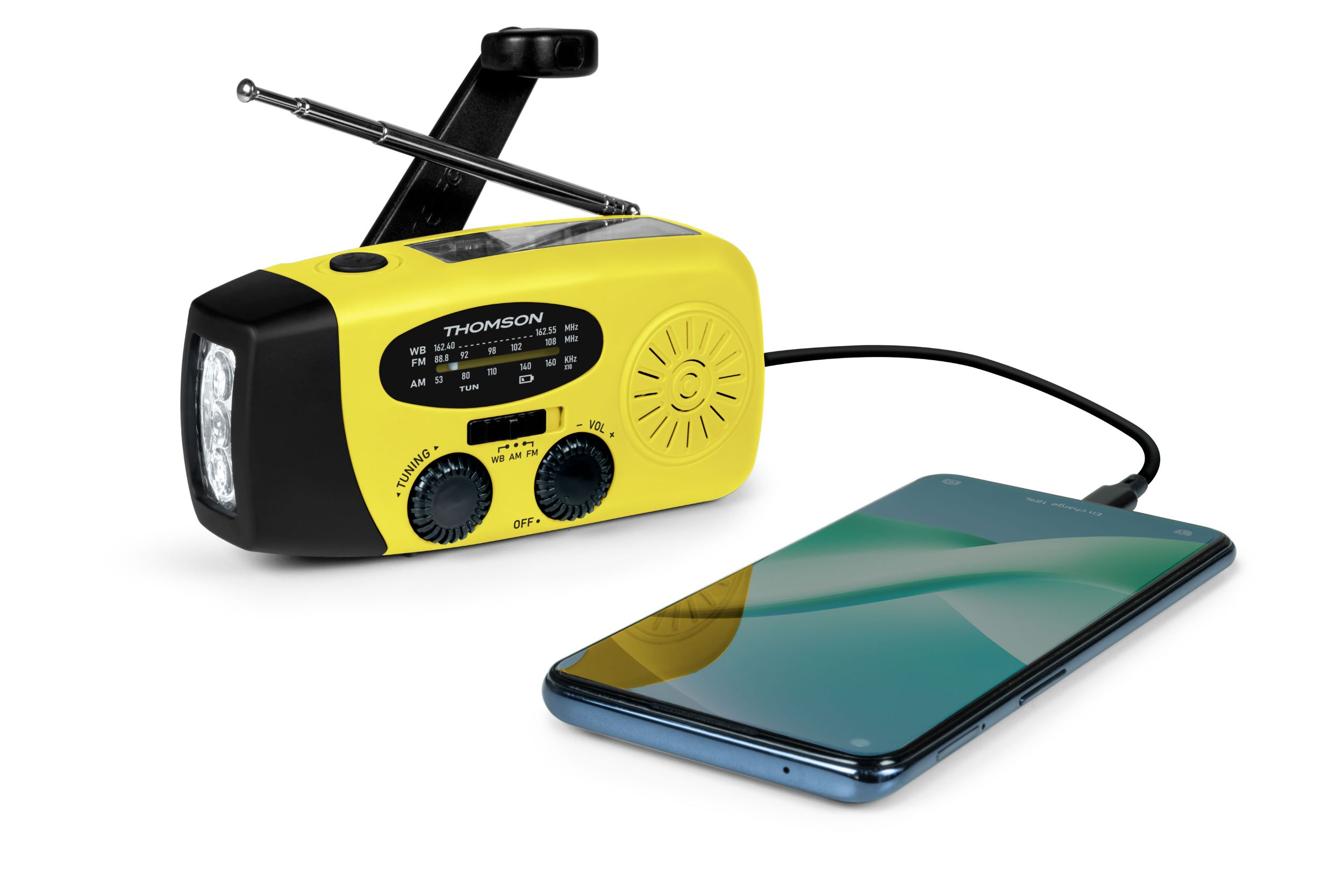 Una radio amarilla con un teléfono cargando. El teléfono es azul. La radio tiene un asa y una antena negras.