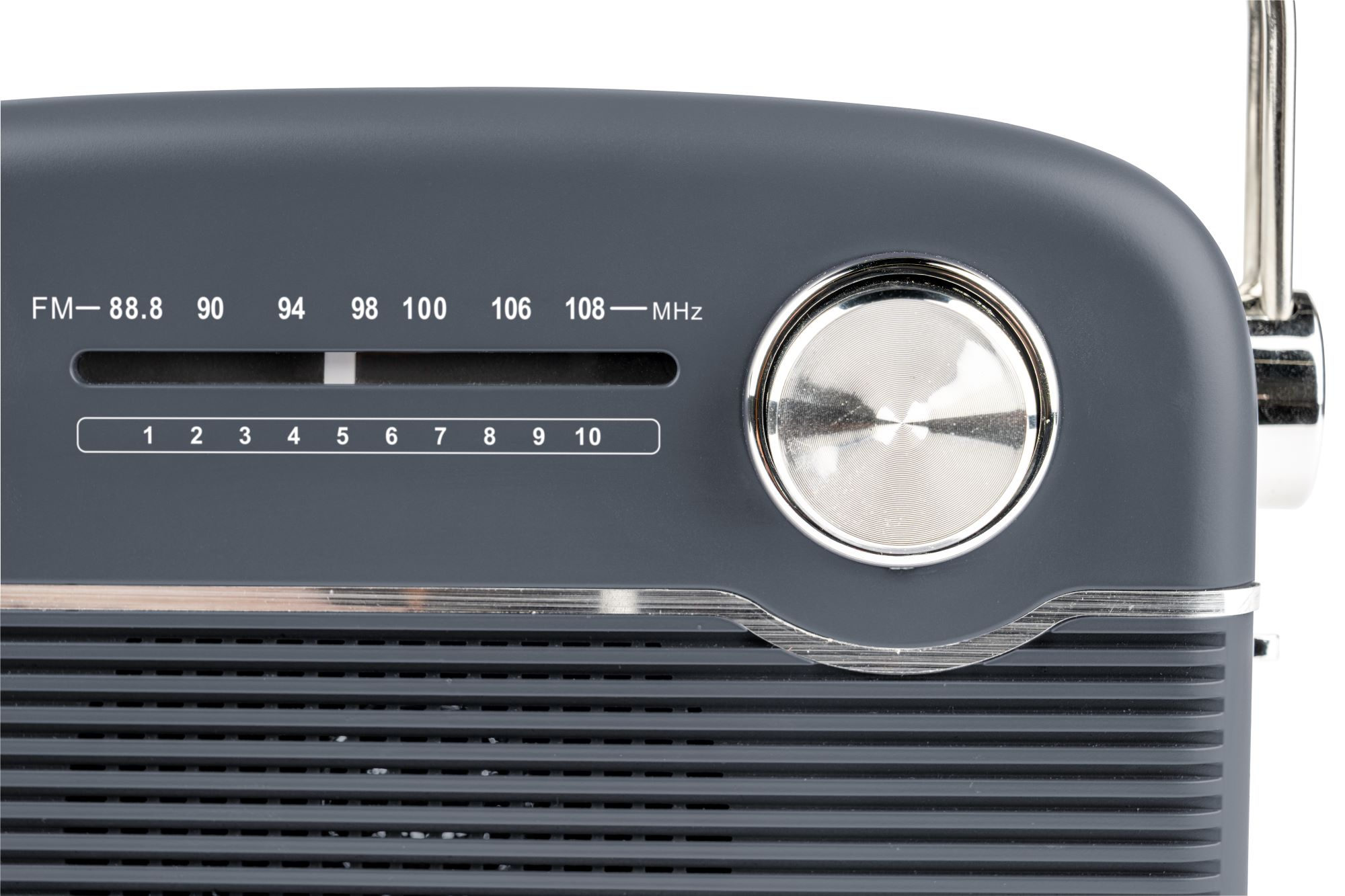 Zbliżenie szarego radia retro. Wyświetla częstotliwości FM i pokrętło. Srebrne pokrętło i antena są widoczne.