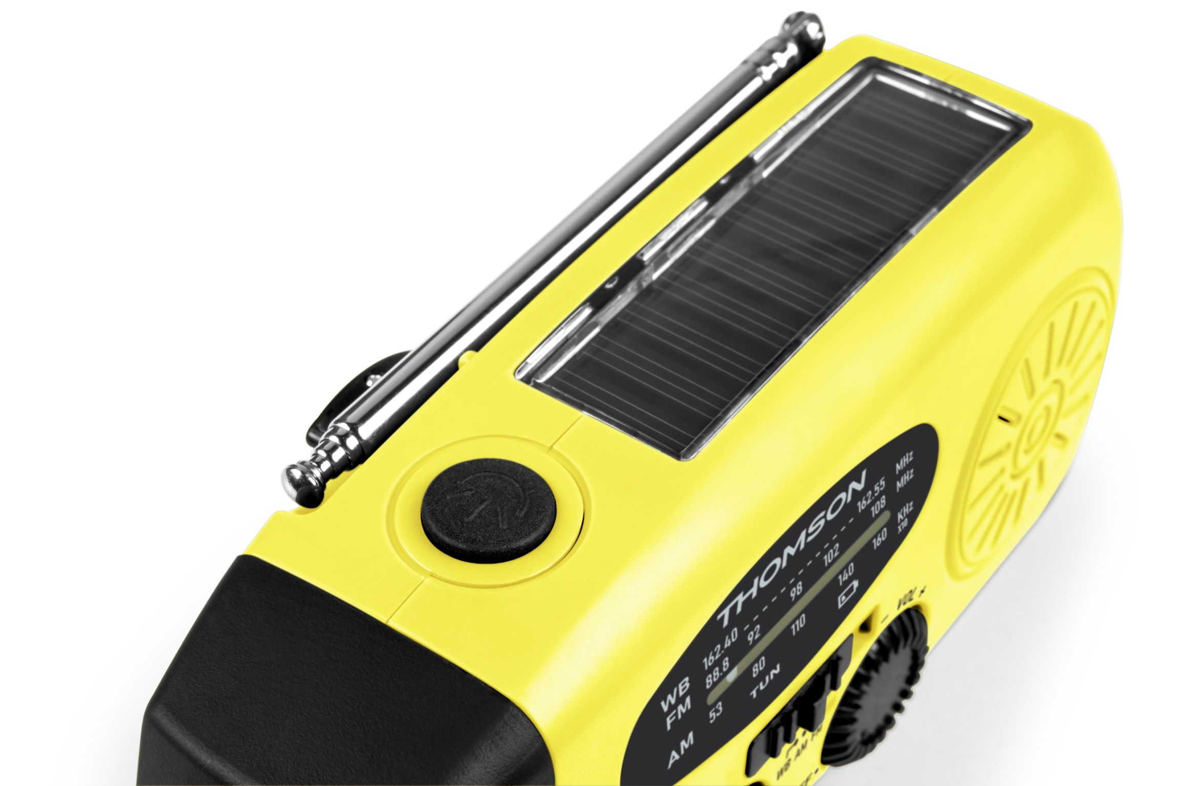 Una radio Thomson amarilla con un panel solar arriba. Tiene antena, botón y dial negros. La radio está sobre una superficie blanca.