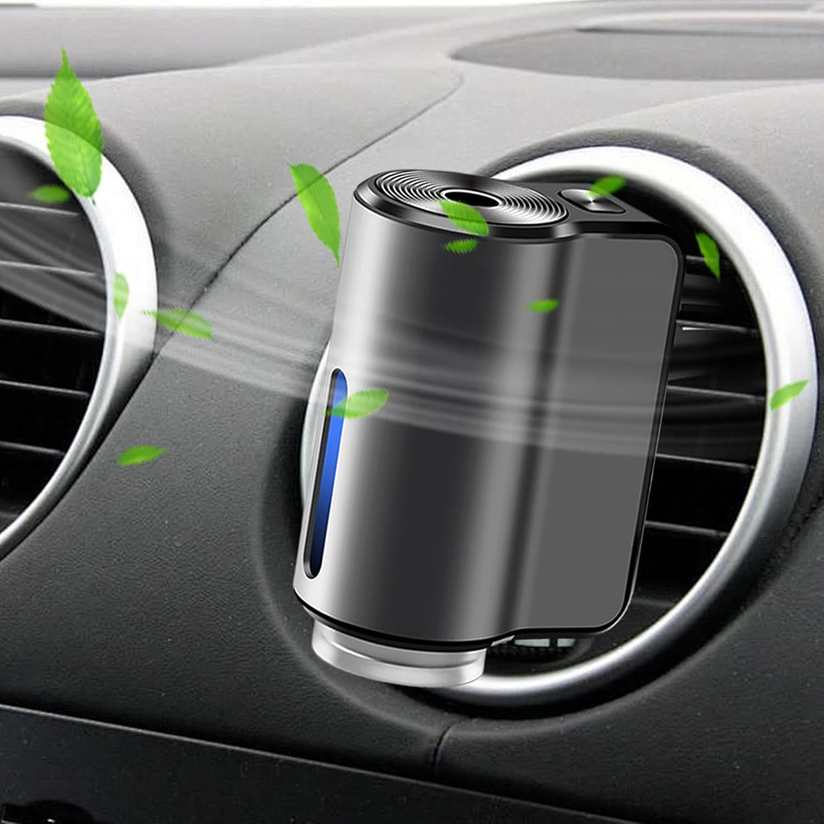 Un ambientador de coche está colocado en la rejilla de ventilación. Hojas verdes rodean el ambientador. El ambientador es negro y plateado.