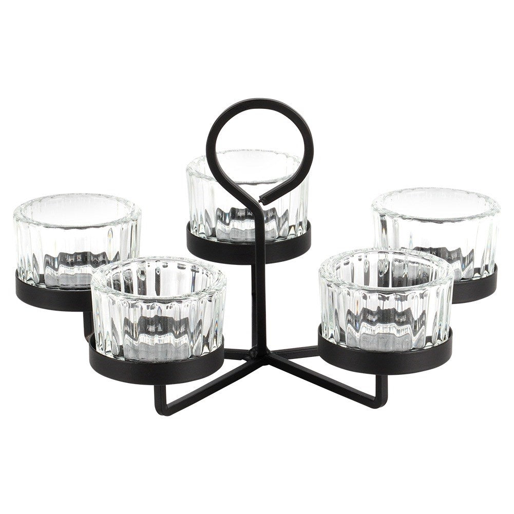 Un portavelas de metal negro con cinco copas de vela de vidrio. El soporte tiene un asa circular en la parte superior.