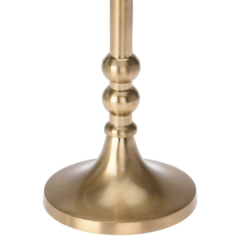 Una base dorada de candelabro con base redonda y un tallo con acentos esféricos. El fondo es blanco.