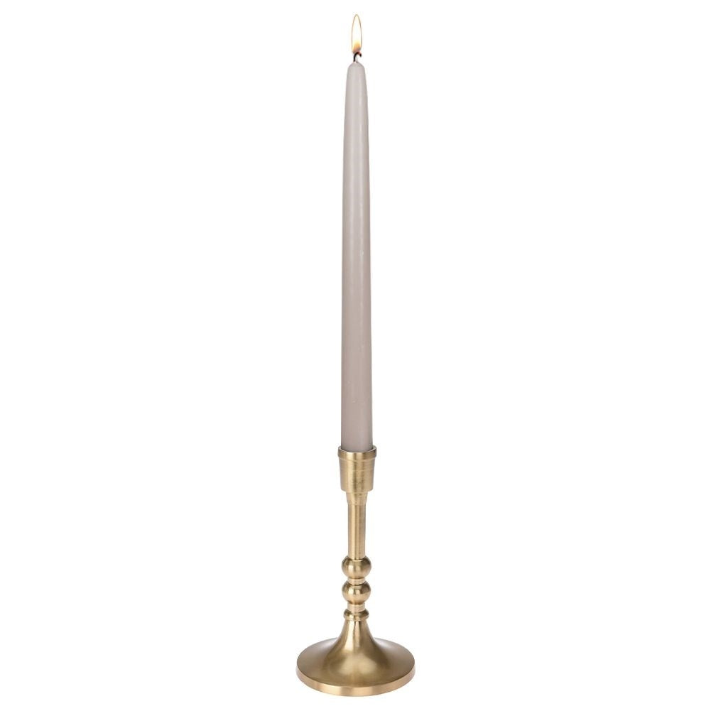Una vela gris delgada y encendida se encuentra sobre un candelabro dorado. El fondo es blanco.