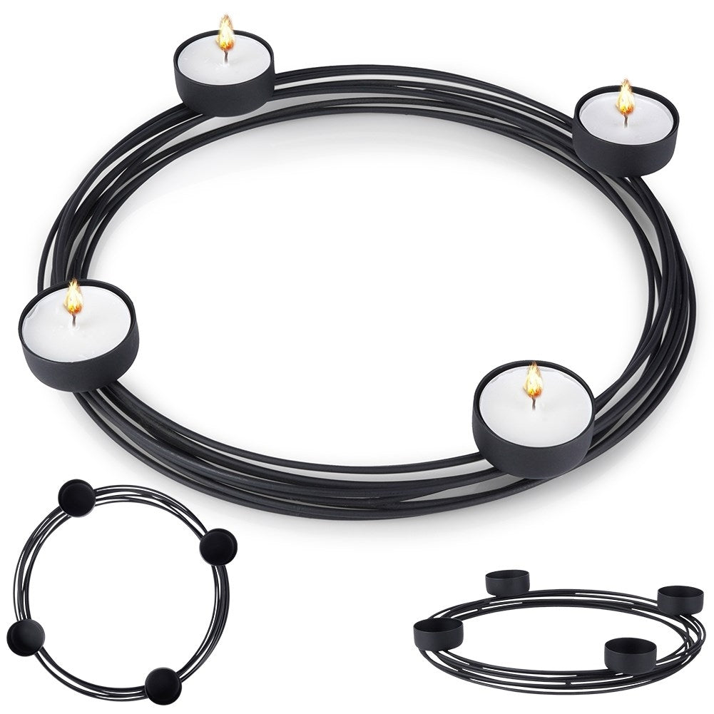 Un portavelas circular negro con cuatro velas encendidas y dos versiones más pequeñas debajo, todo sobre un fondo blanco.