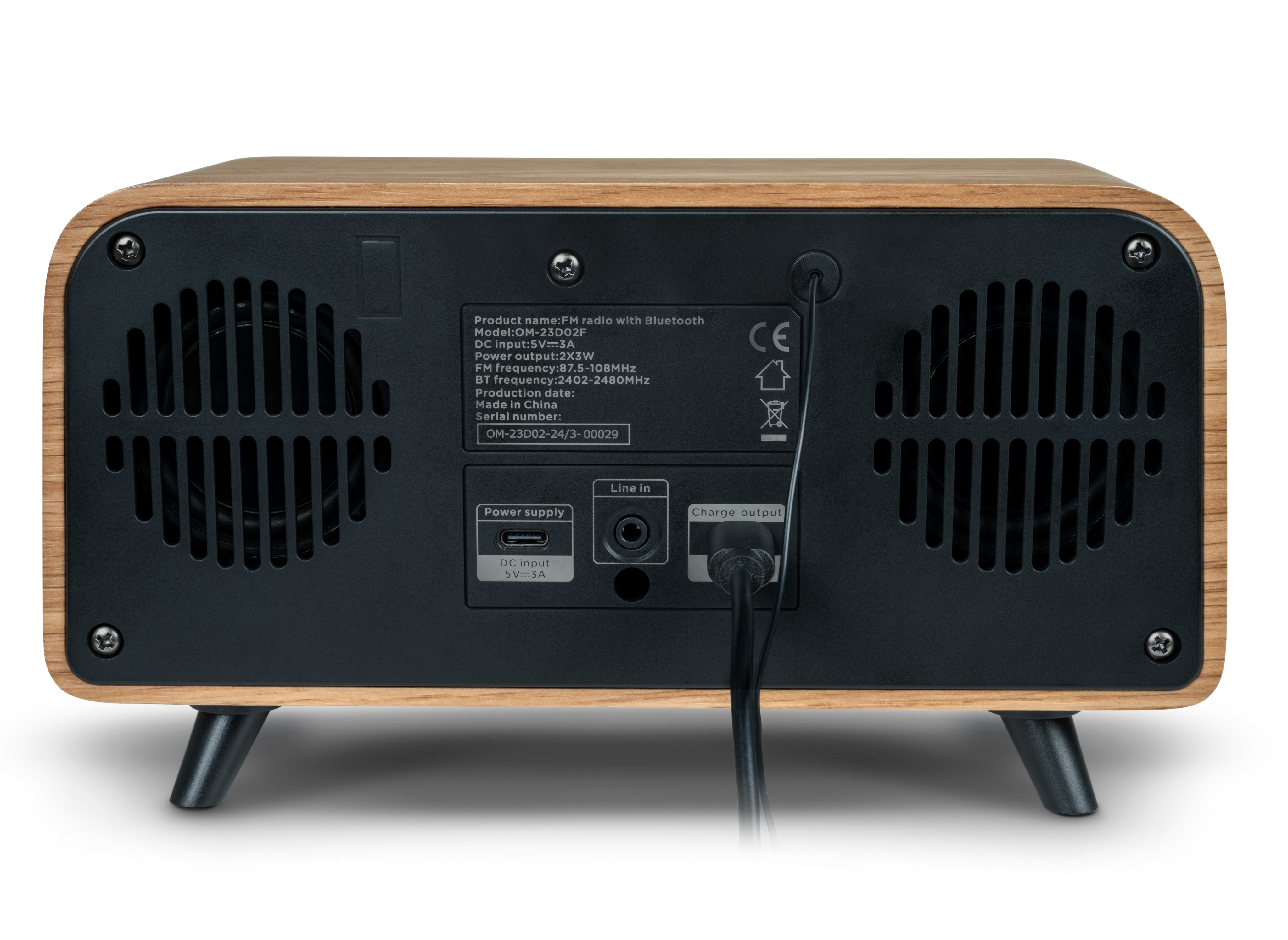 Rear view of a wooden radio with black speaker grilles and input/output ports. A power cable is plugged in.