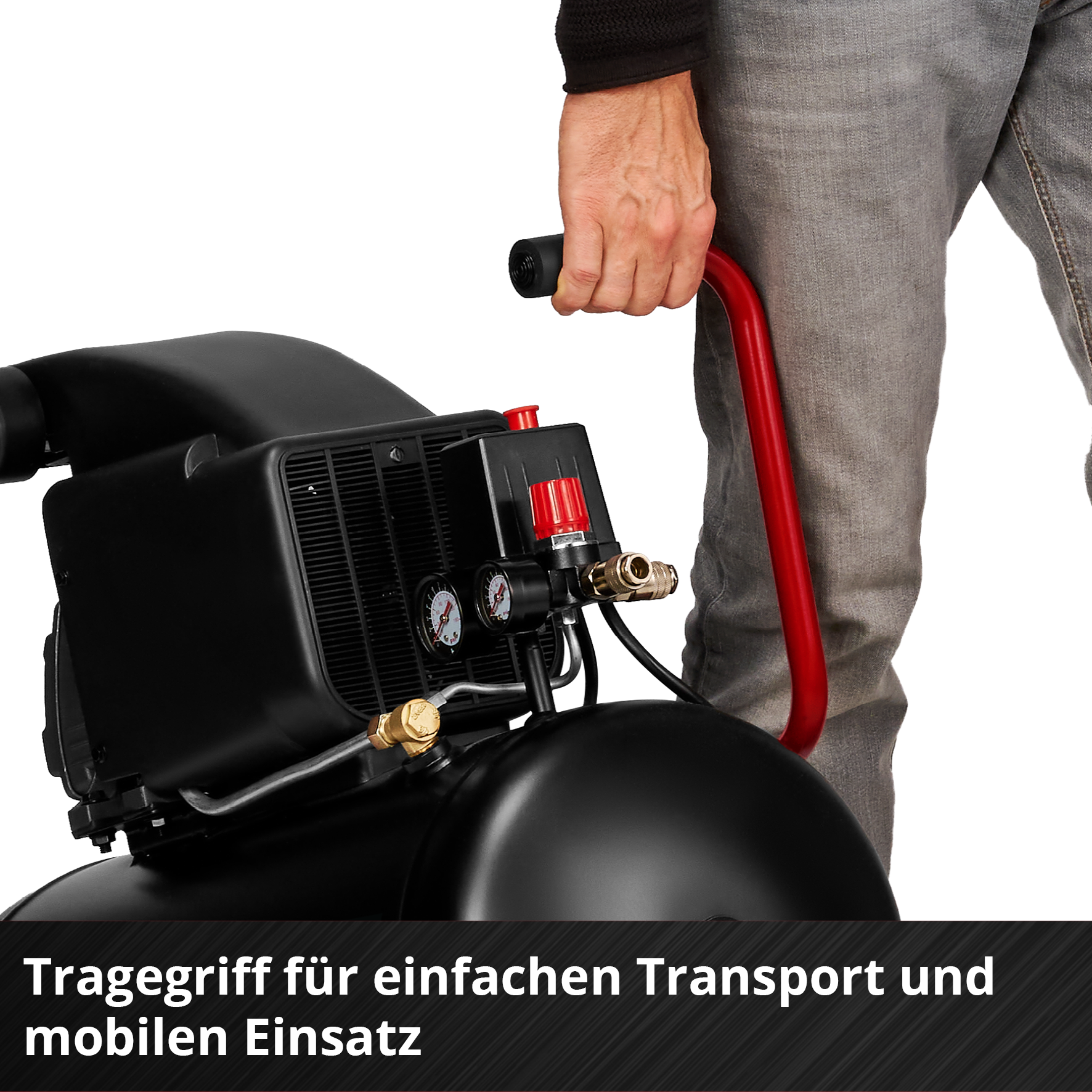 Eine Person hält einen schwarzen Luftkompressor an seinem roten Griff. Der Kompressor hat Anzeigen und Messingarmaturen.