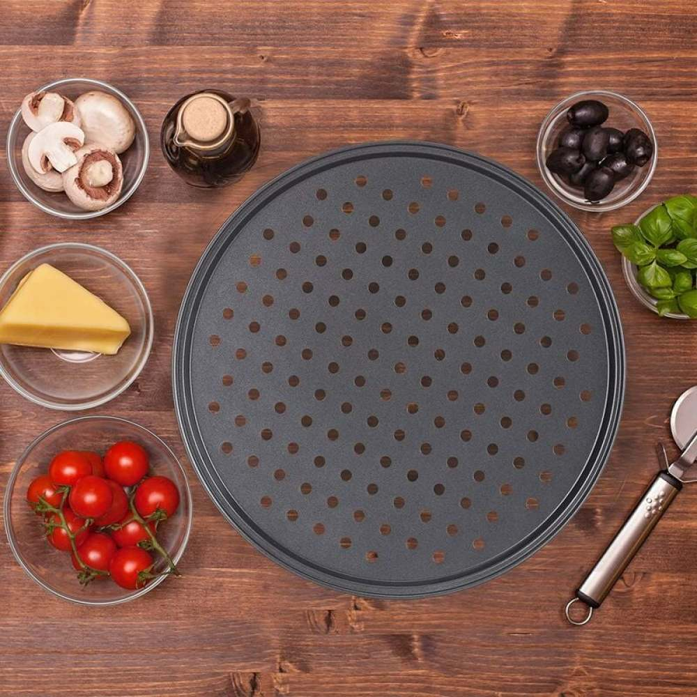 Zutaten für Pizza auf einem Holztisch: Tomaten, Pilze, Oliven, Käse, Basilikum, Öl und eine Pizza-Pfanne.