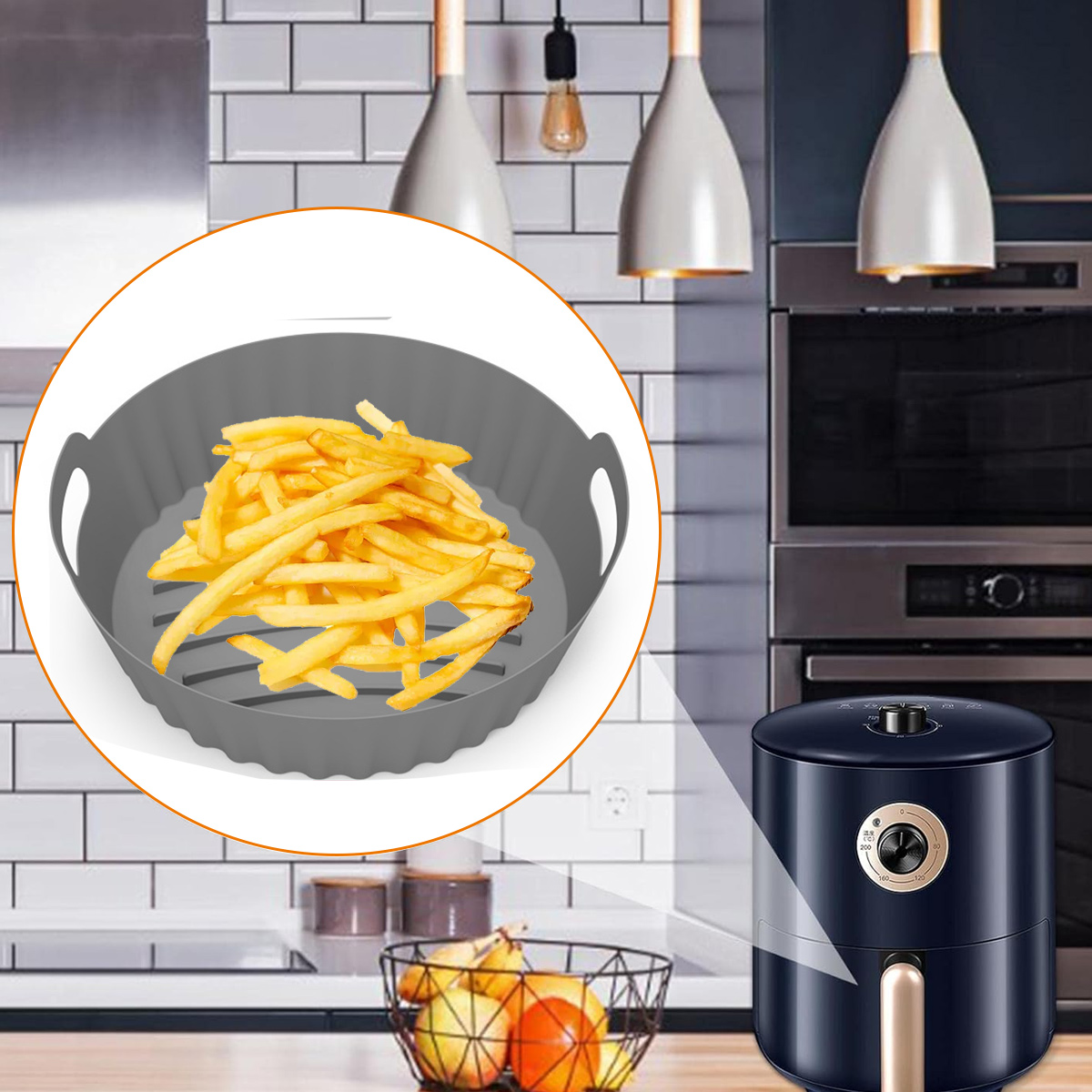 Nahaufnahme von Pommes Frites in einem grauen Airfryer-Korb. Rechts ein schwarzer Airfryer. Im Hintergrund Lichter und ein Ofen.