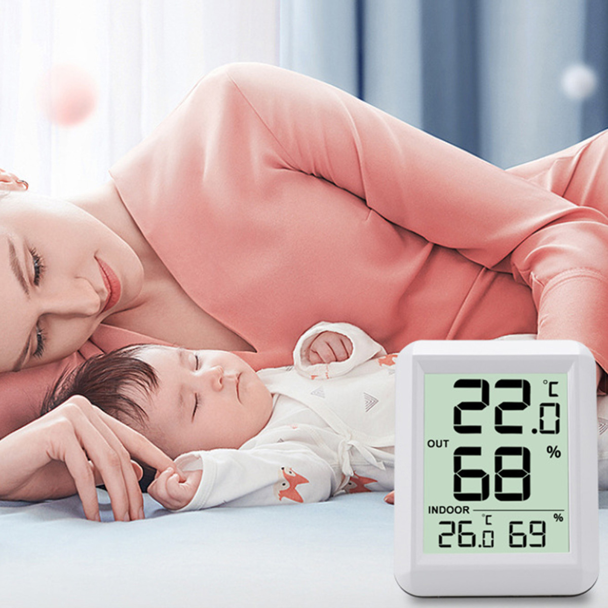 Eine Frau und ein Baby liegen. Ein Thermometer befindet sich in der Nähe. Die Frau lächelt und berührt das Baby. Das Baby schläft.