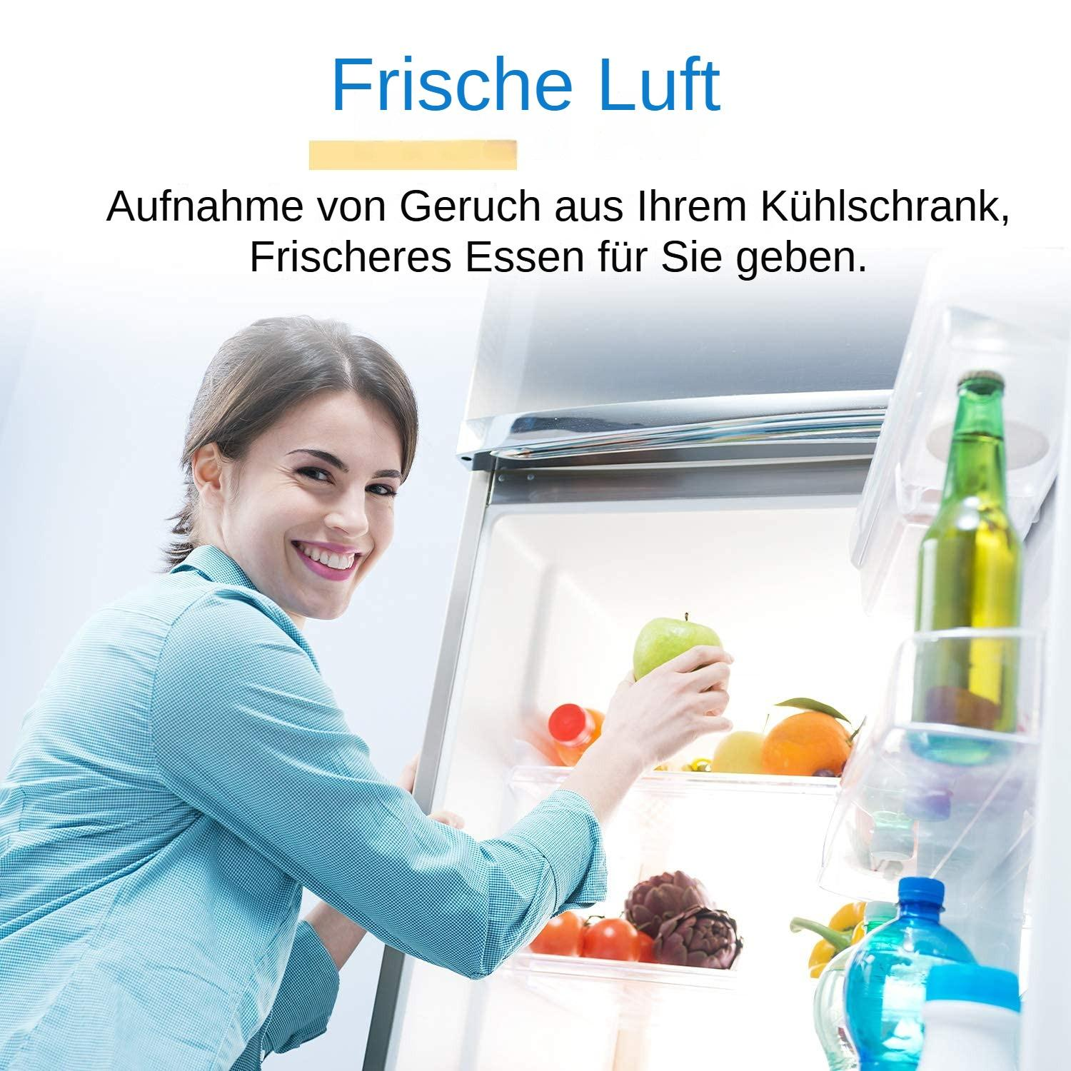 Eine lächelnde Frau hält einen grünen Apfel in einem geöffneten Kühlschrank mit Früchten und Flaschen.