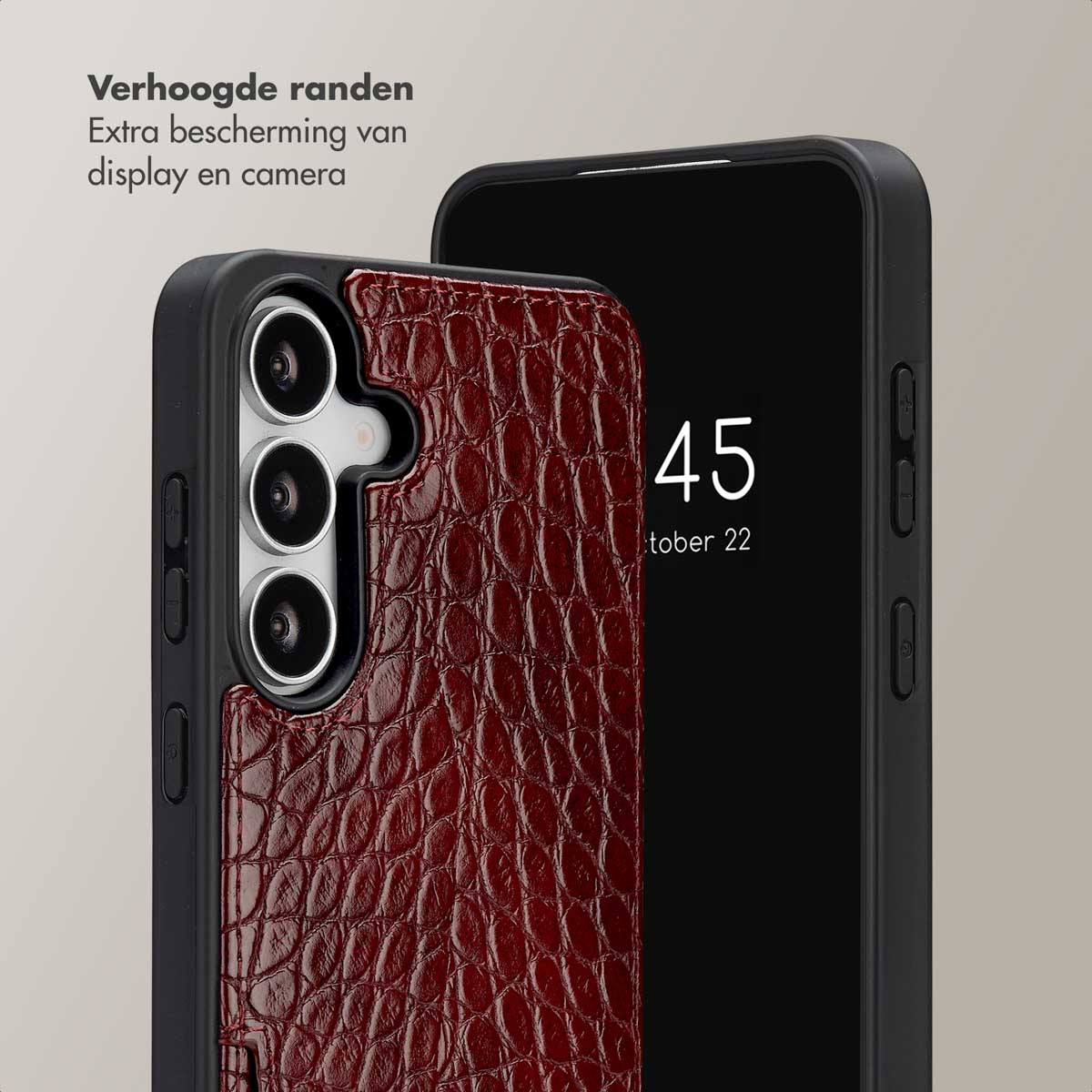 Close-up van een telefoon in een bordeauxrode, getextureerde hoes. Er staat nog een telefoon naast. Tekst op het scherm: 45 oktober 22.