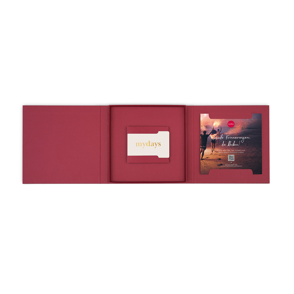 Geöffnete rote Geschenkbox mit 'mydays' Geschenkkarte und einem Einsatz mit Strandbild. Text: 'schöne Erinnerungen'.