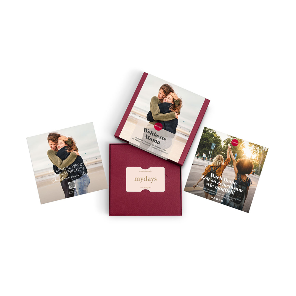 Vier mydays-Produkte: eine Geschenkbox und drei Karten. Die Karten zeigen Bilder von umarmenden Menschen und Werbetext.
