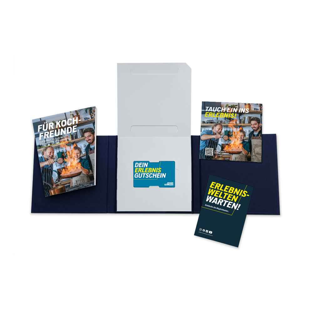 Offenes Geschenkset mit Broschüren und einer Geschenkkarte. Die Broschüren werben für Kochkurse und Erlebnisse.