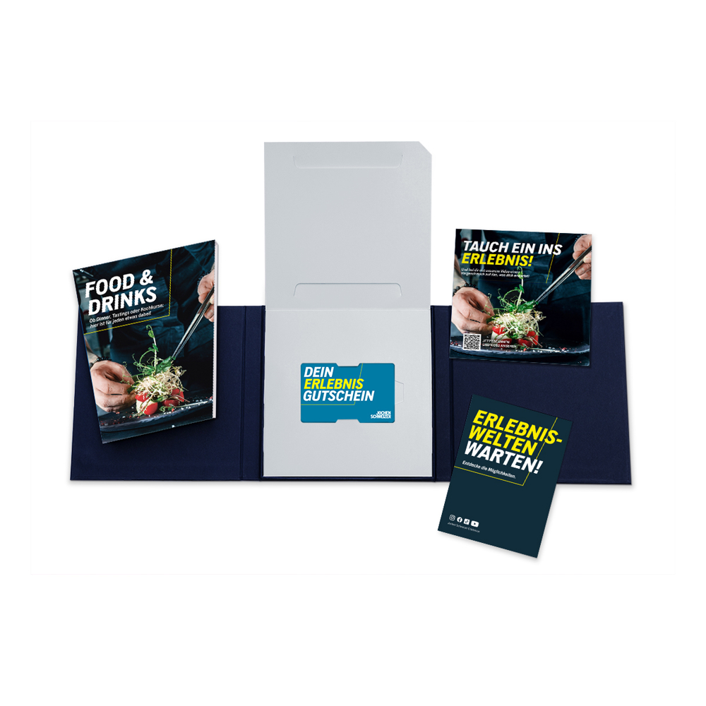 Geöffnete Geschenkbox mit Broschüren für Essen und Erlebnisse. Enthält einen Gutschein und Werbematerialien.