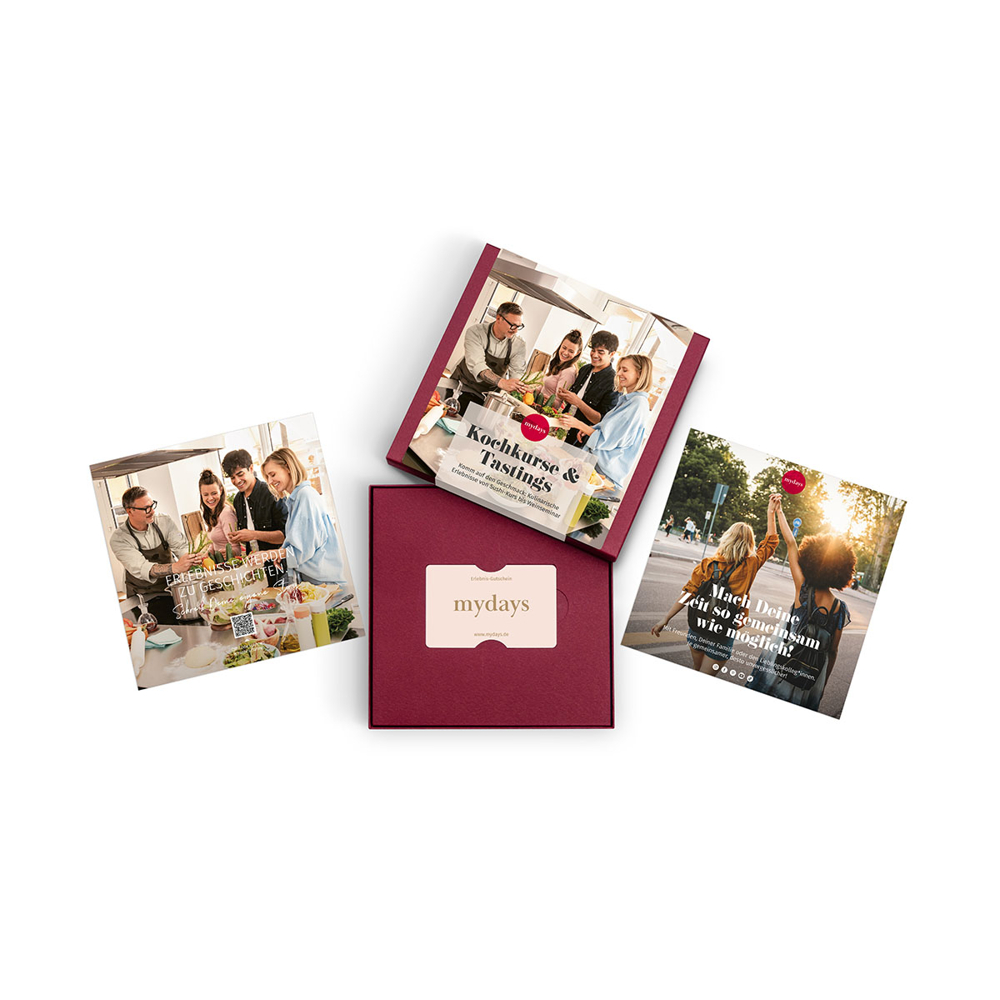 Das Bild zeigt ein mydays-Geschenkset mit vier Karten. Eine Karte zeigt eine Kochkursszene, eine andere Personen, zwei Frauen heben Hände, und eine Geschenkbox.