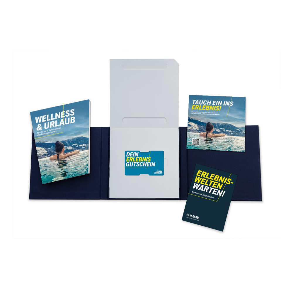 Offenes Geschenkset mit Broschüren und einer Geschenkkarte. Die Broschüren werben für Wellness- und Abenteuererlebnisse. Dunkelblauer Ordner.