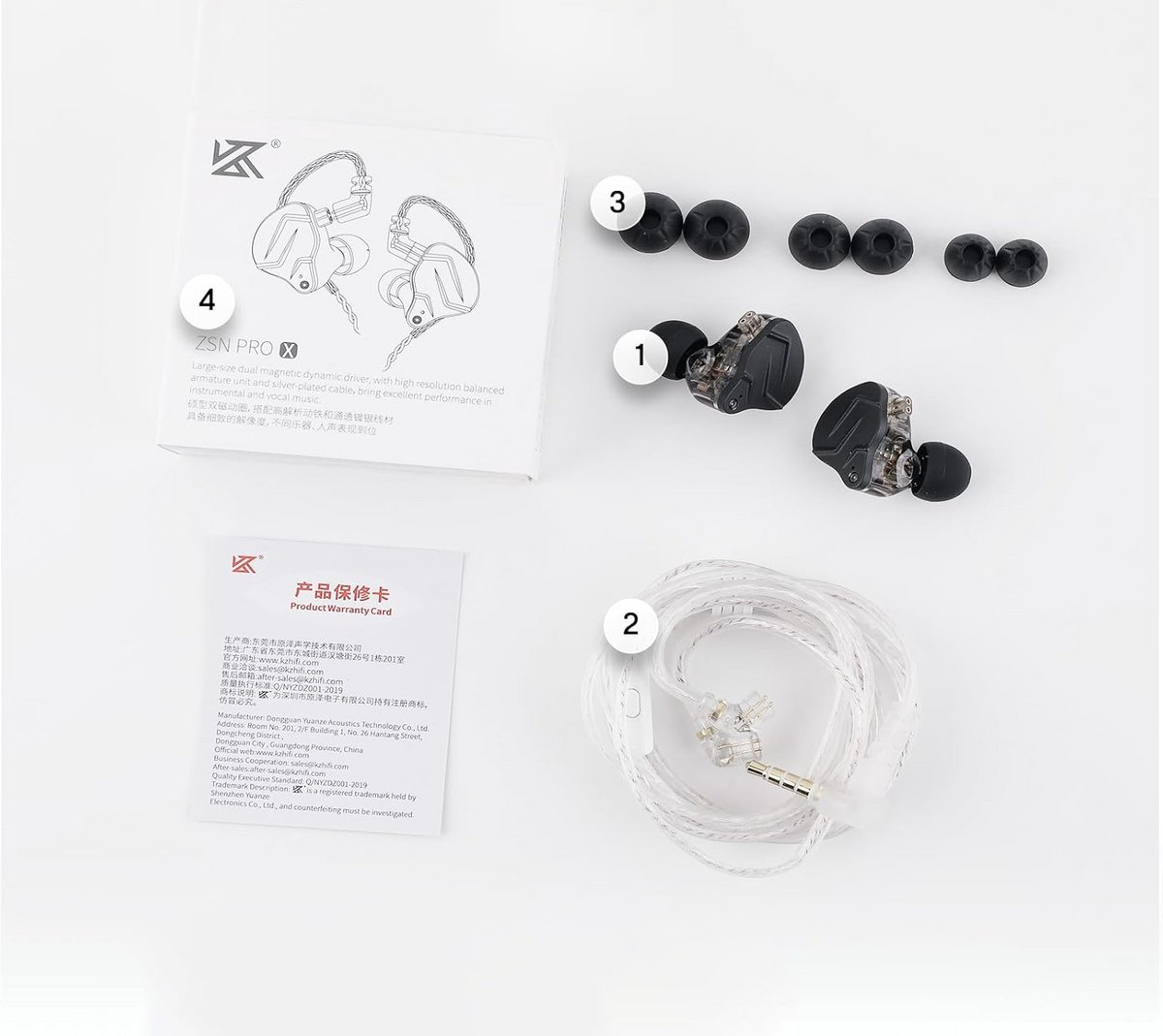 Oortelefoons met extra oordopjes, garantiekaart en kabel op een wit oppervlak.