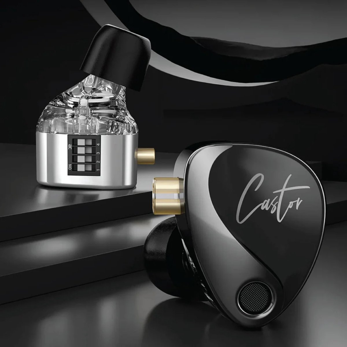 Earphones with black and silver design. One is open, showing the inside components. The other is closed with "Castor" written on it.