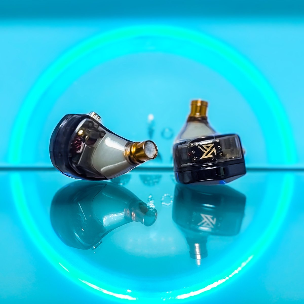 Two in-ear monitors with gold accents on a reflective blue surface, against a blue background with a circular glow.