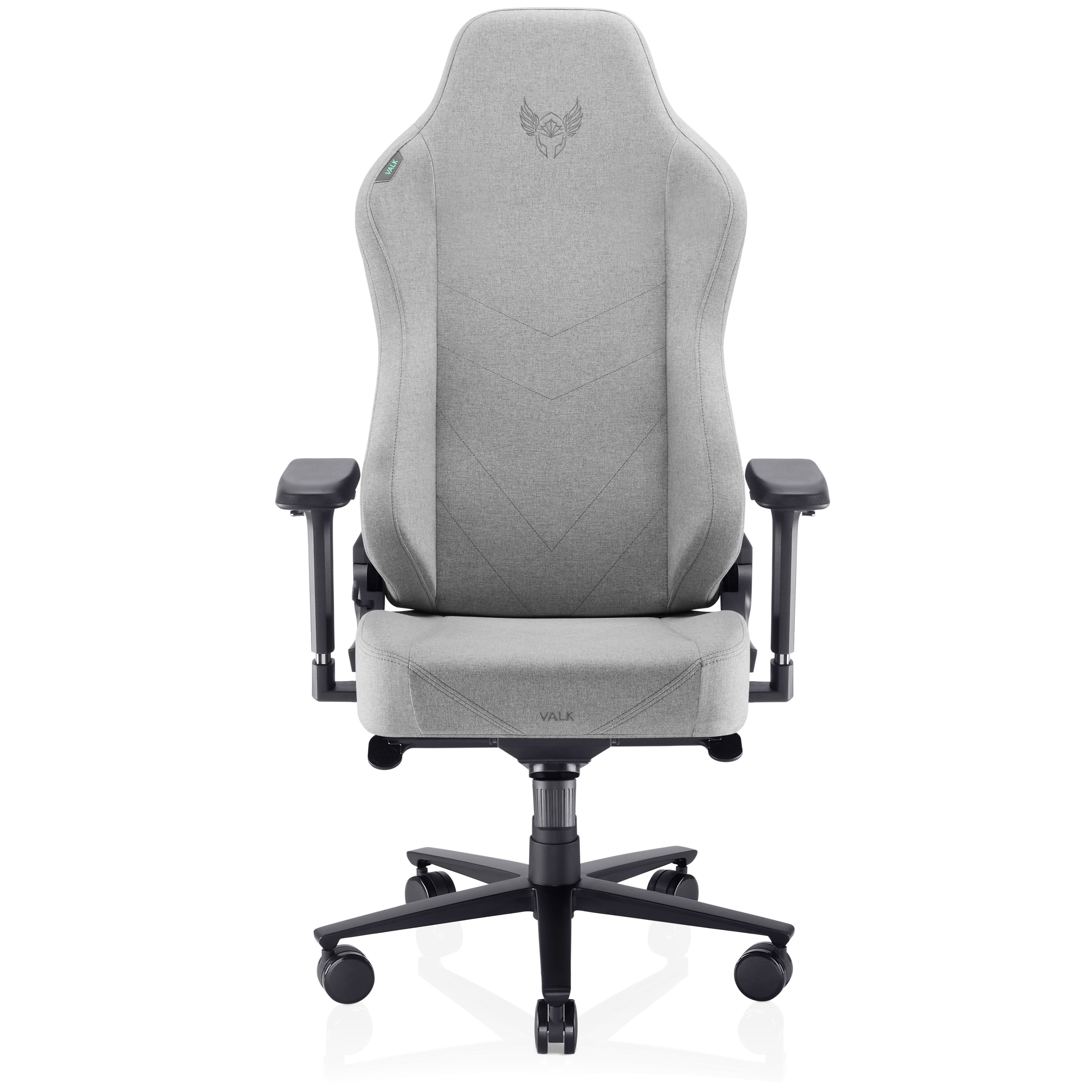 Una silla gaming VALK gris está centrada. Tiene respaldo alto, reposabrazos y base de cinco estrellas con ruedas, sobre fondo blanco.