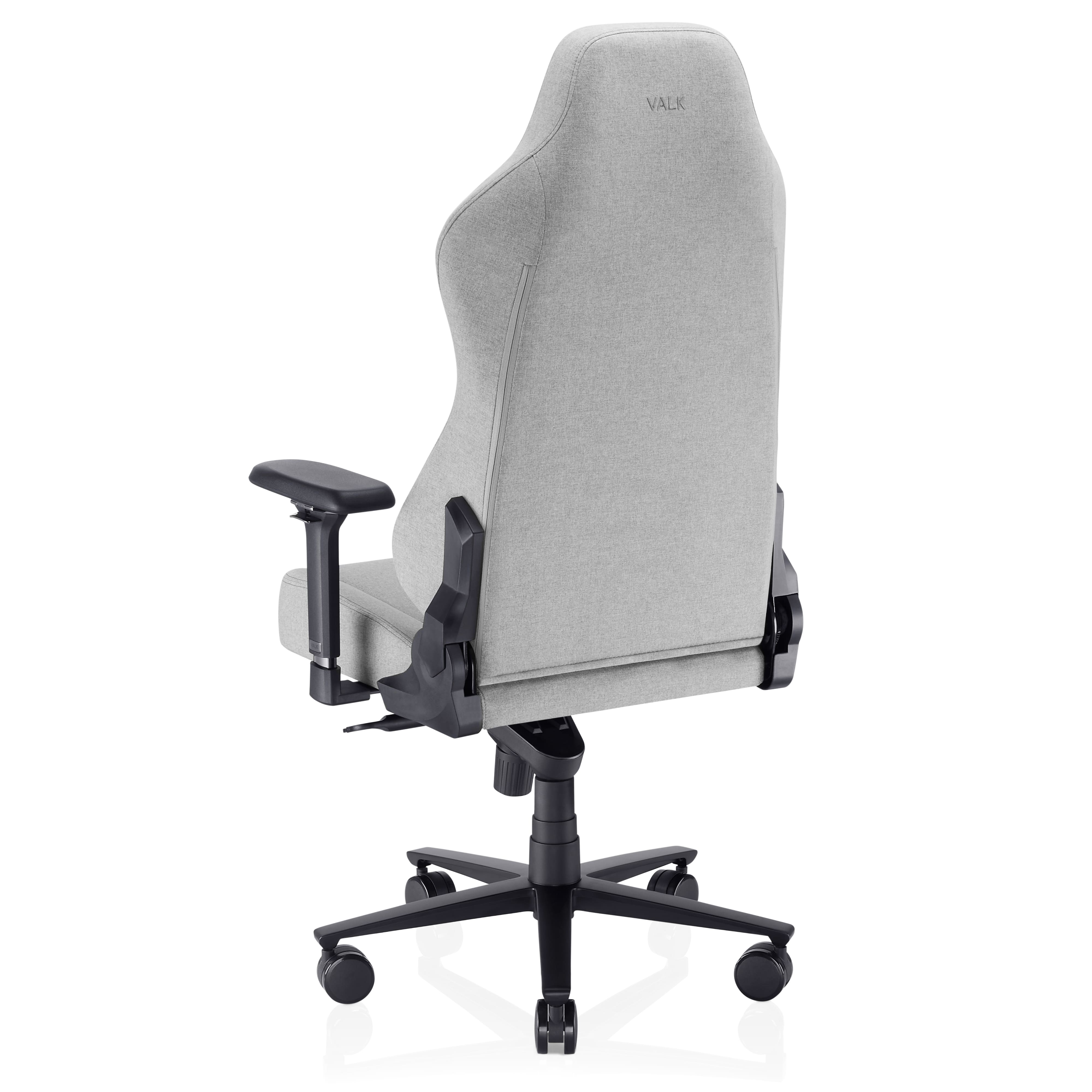 Una silla gaming VALK gris vista desde atrás. Tiene reposabrazos negros y una base negra con ruedas, sobre fondo blanco.