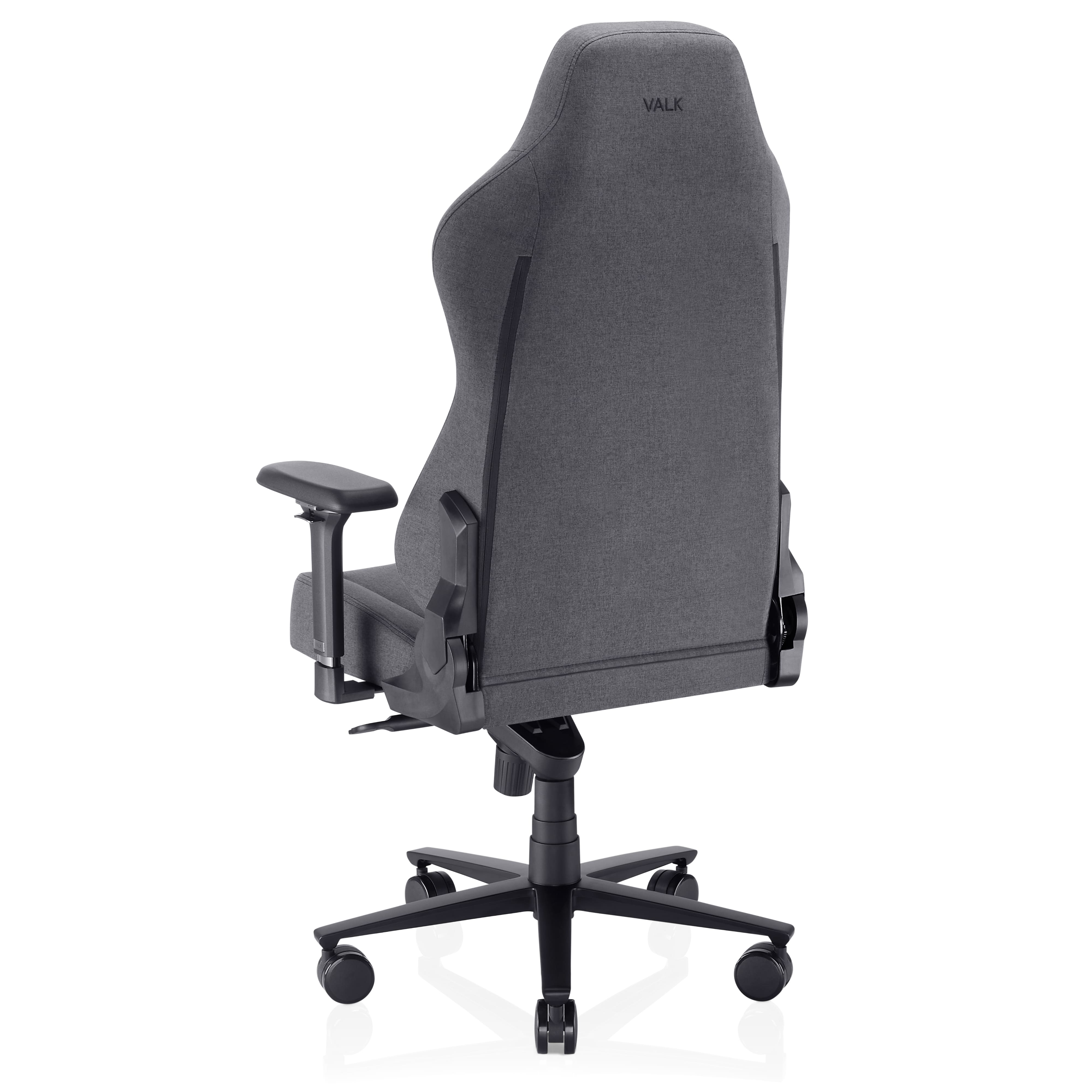 Silla gaming gris sobre fondo blanco. Tiene respaldo alto con 'VALK' y reposabrazos. Base negra con ruedas.