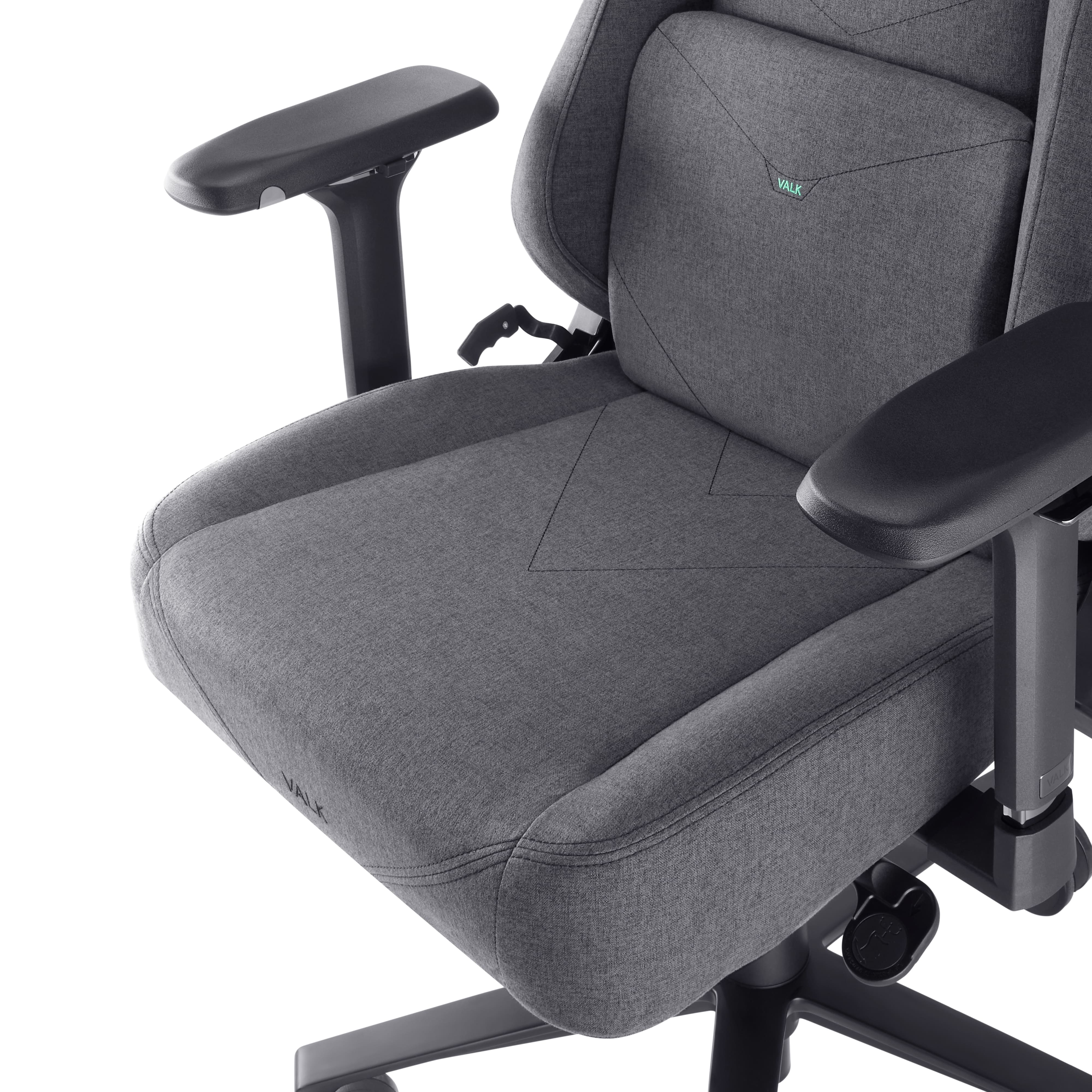Una silla gaming gris con reposabrazos y base negros. La silla tiene un logo 'VALK'.