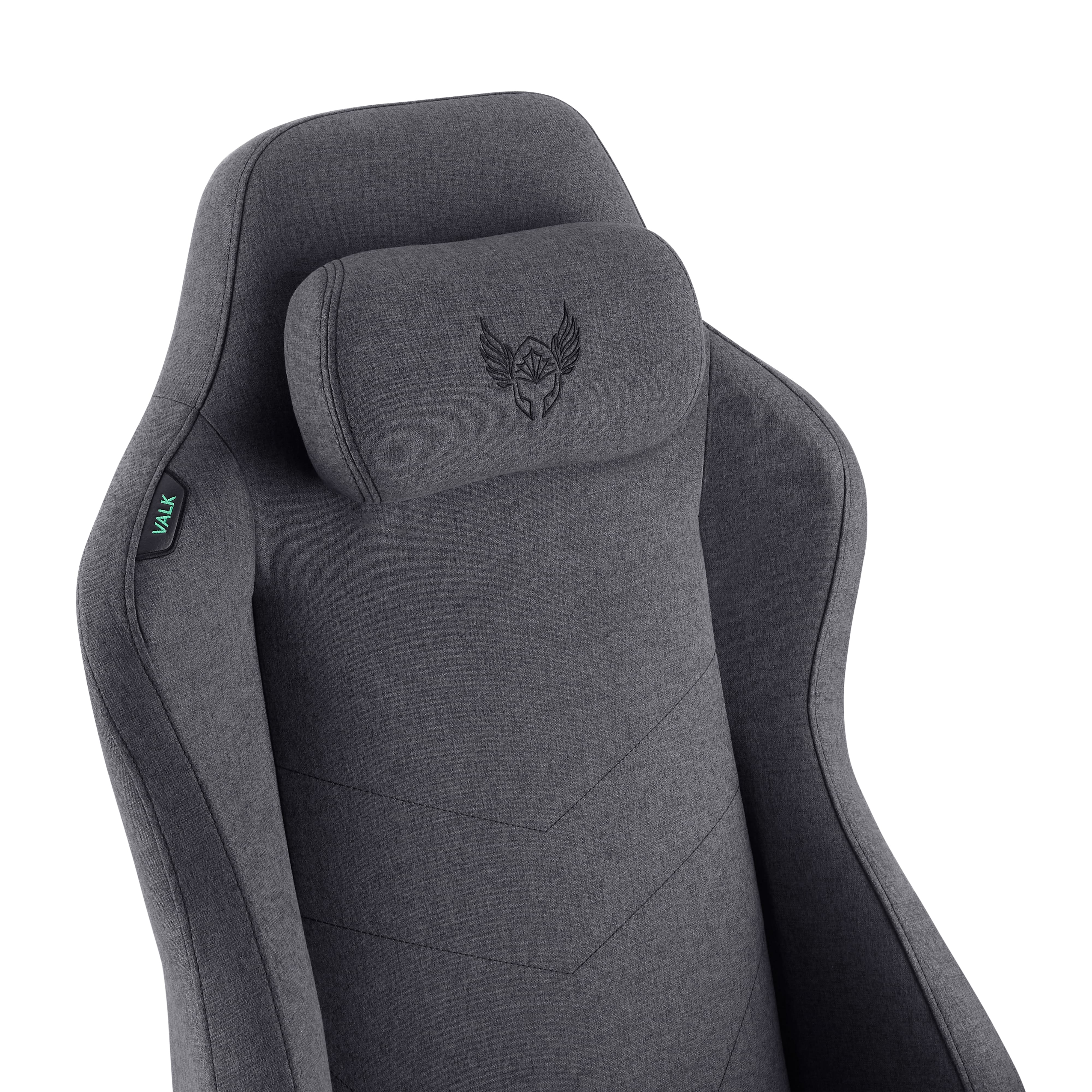 Primer plano de una silla gaming gris. Tiene un reposacabezas con un logotipo y la marca 'VALK' en el lateral.