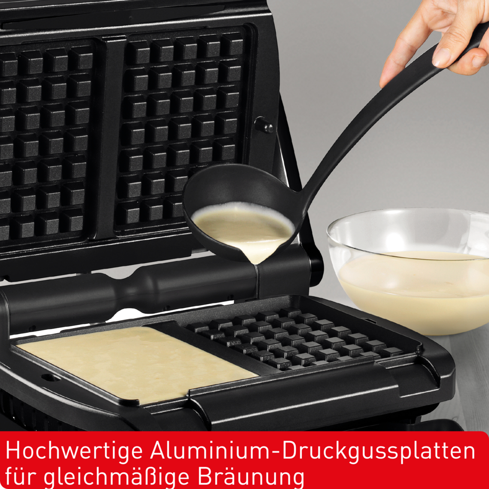 Eine Hand gießt Teig mit einer schwarzen Kelle in ein Waffeleisen. Daneben steht eine Schüssel mit Teig. Das Eisen ist geöffnet.
